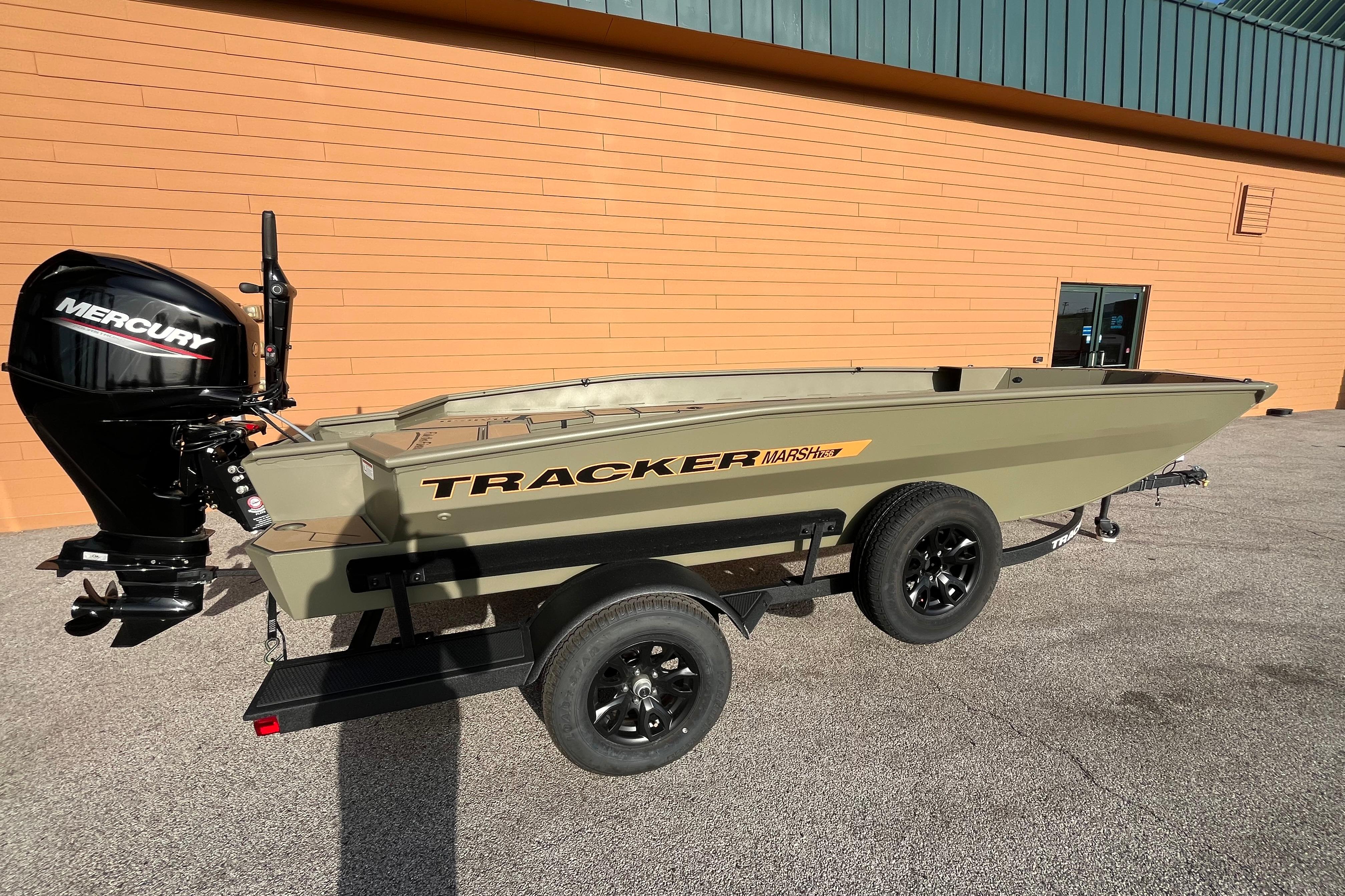 2026 Tracker Grizzly 1756 T Marsh boat with Mercury engine on trailer, parked outdoors.