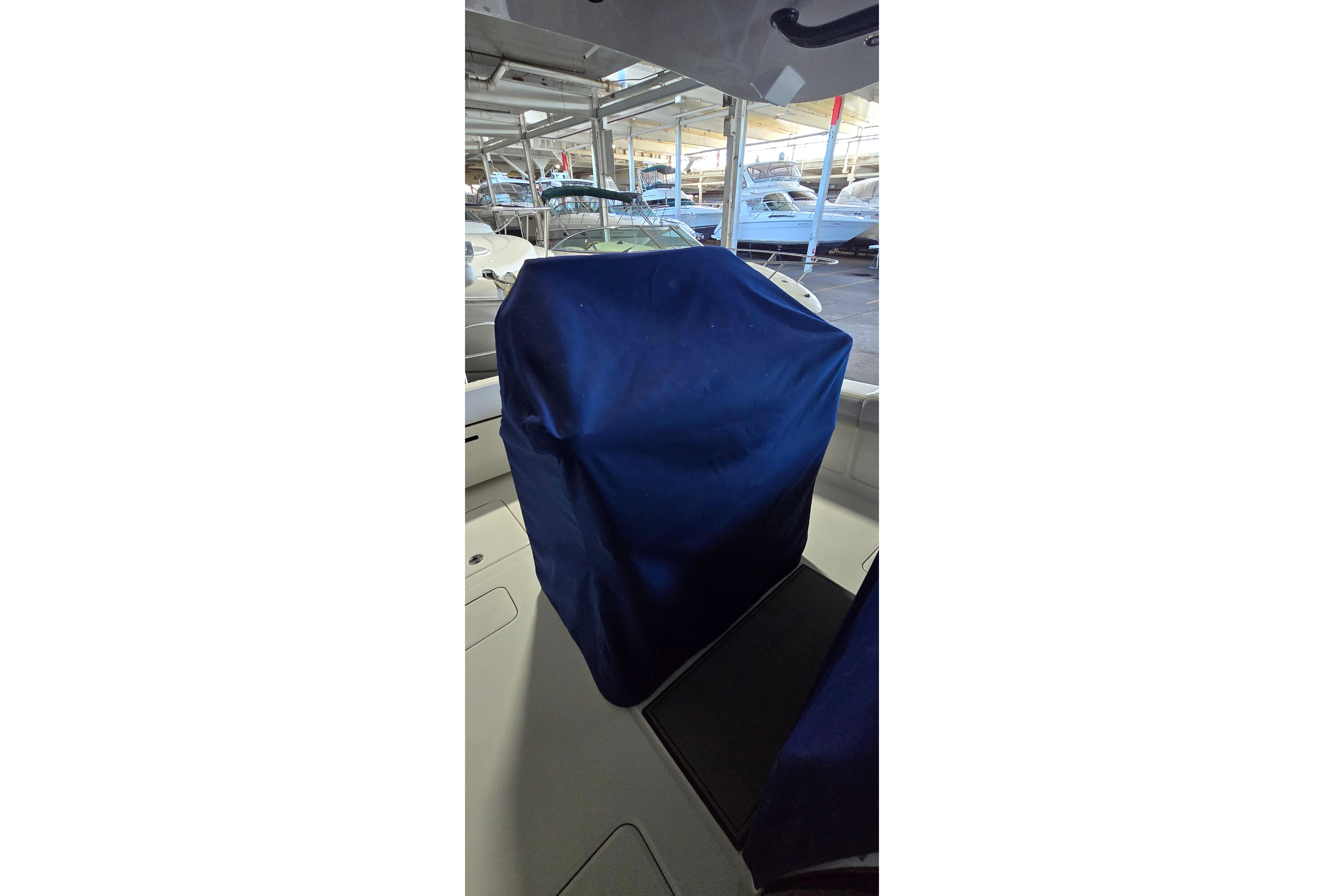 2024 WorldCat 280 CC-X boat interior with blue cover, docked in a marina.