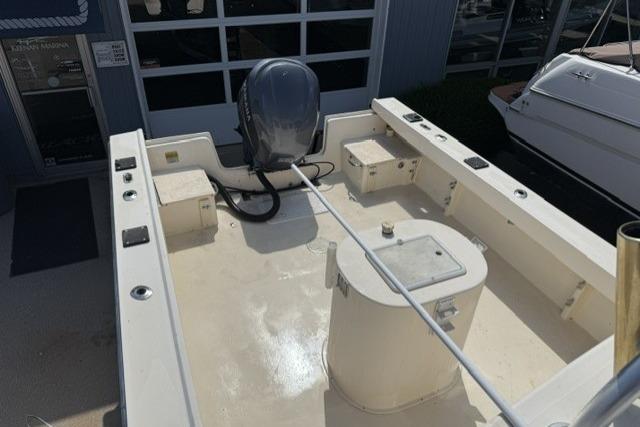 2006 Parker 2520 SL Sport Cabin boat deck with outboard motor, docked near other boats.