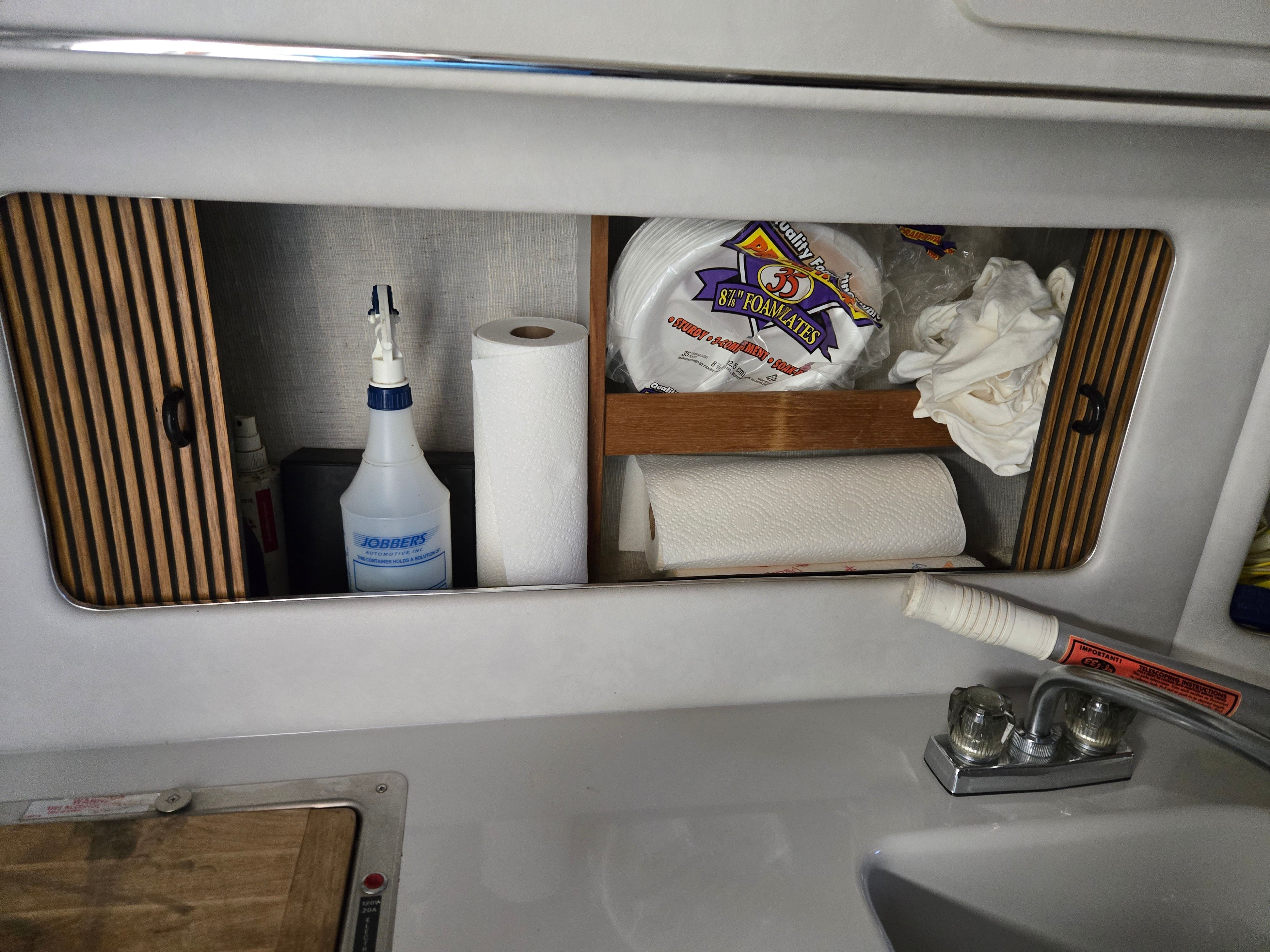 Interior of a boat with cleaning supplies and paper towels.