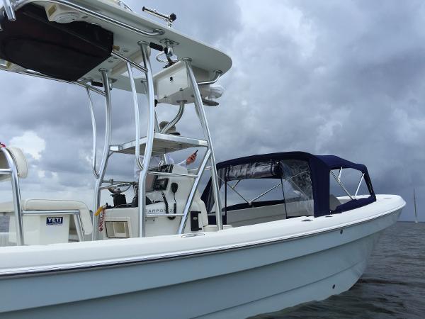 A 2011 Andros 26 Tarpon boat on the water, featuring a blue canopy and a helm station.