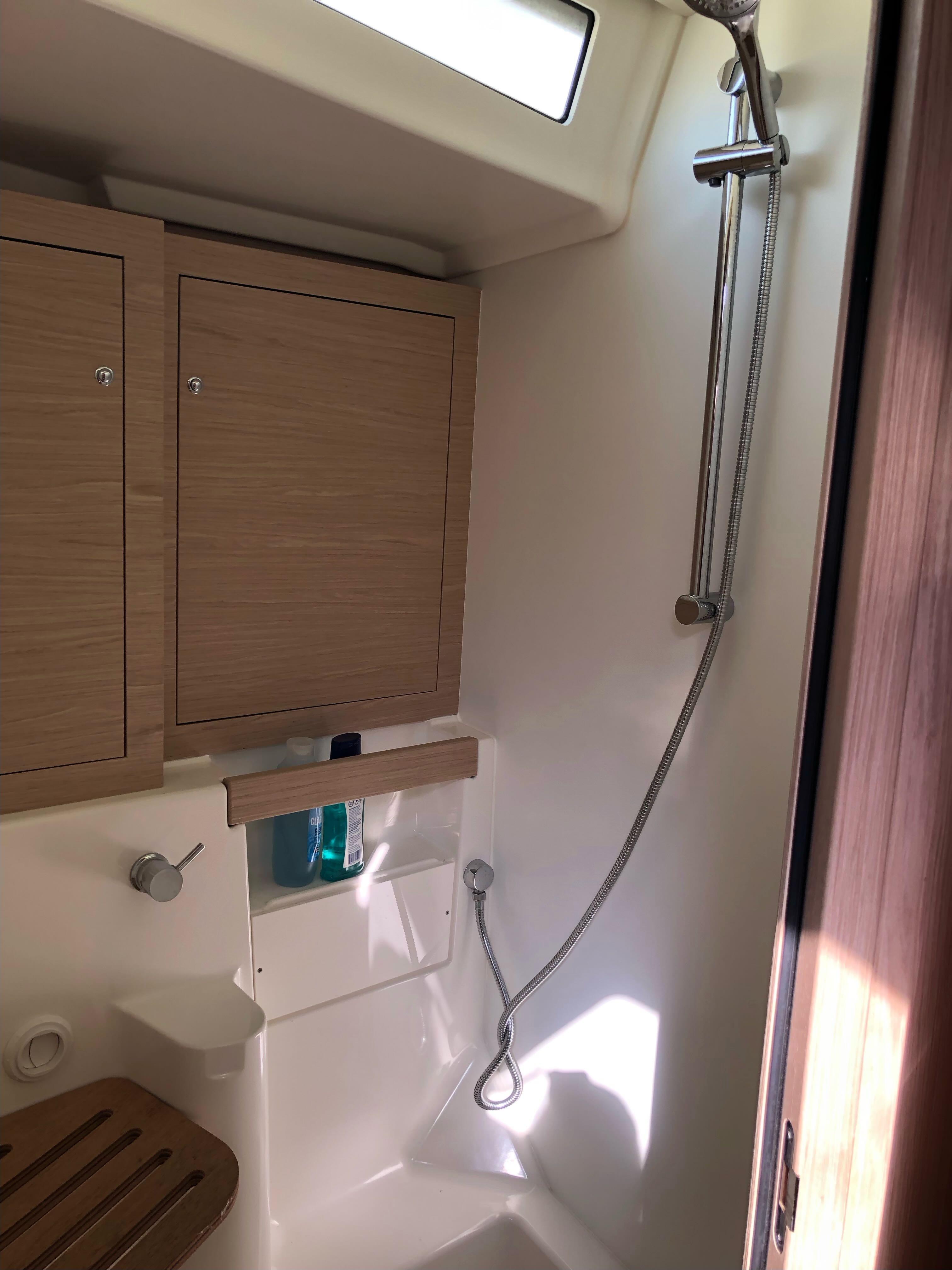 2019 Beneteau Oceanis 51.1 yacht bathroom with shower and wooden cabinets.
