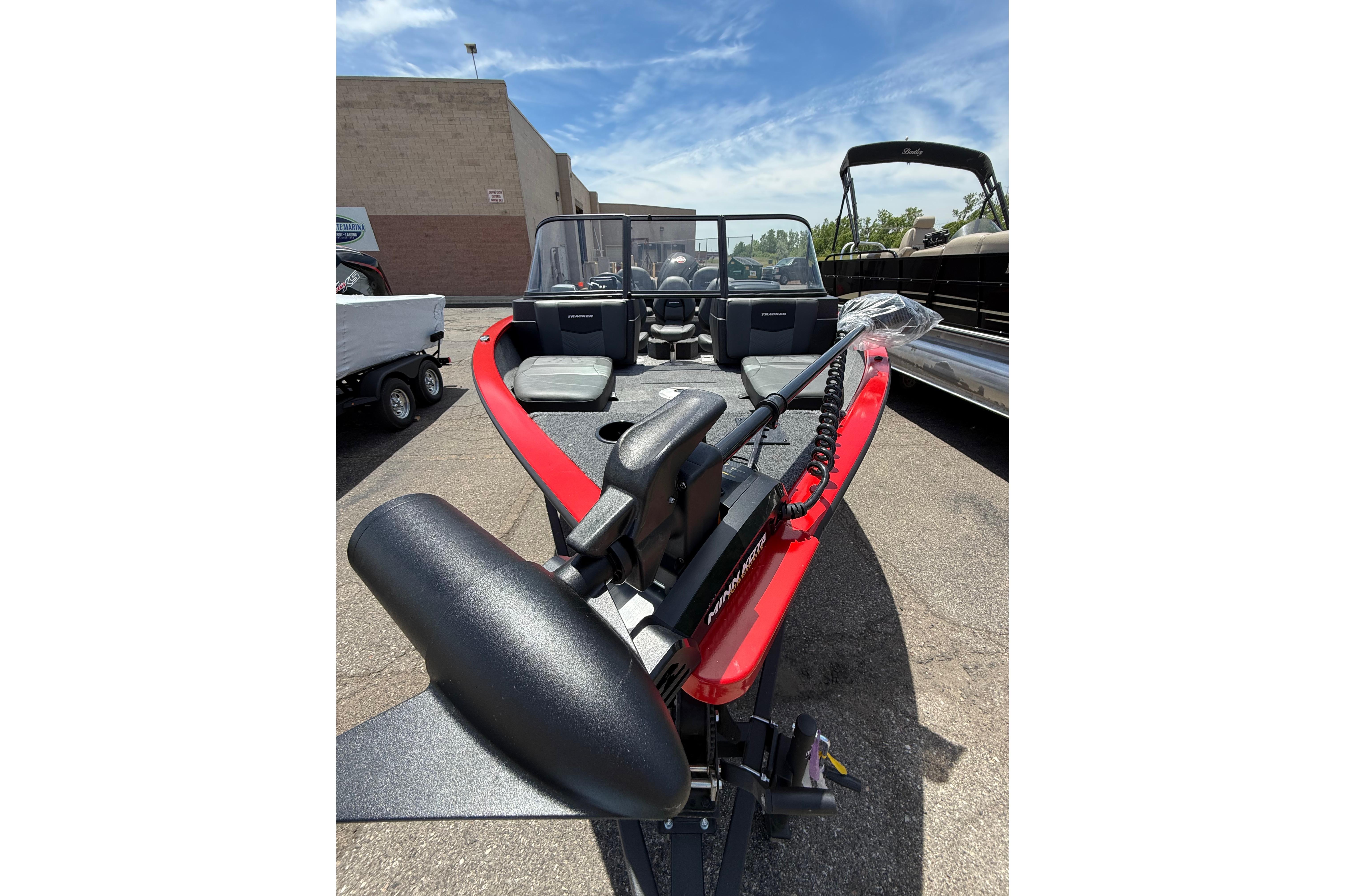 2026 Tracker Pro Guide V-175 Combo boat with red accents, parked outdoors.