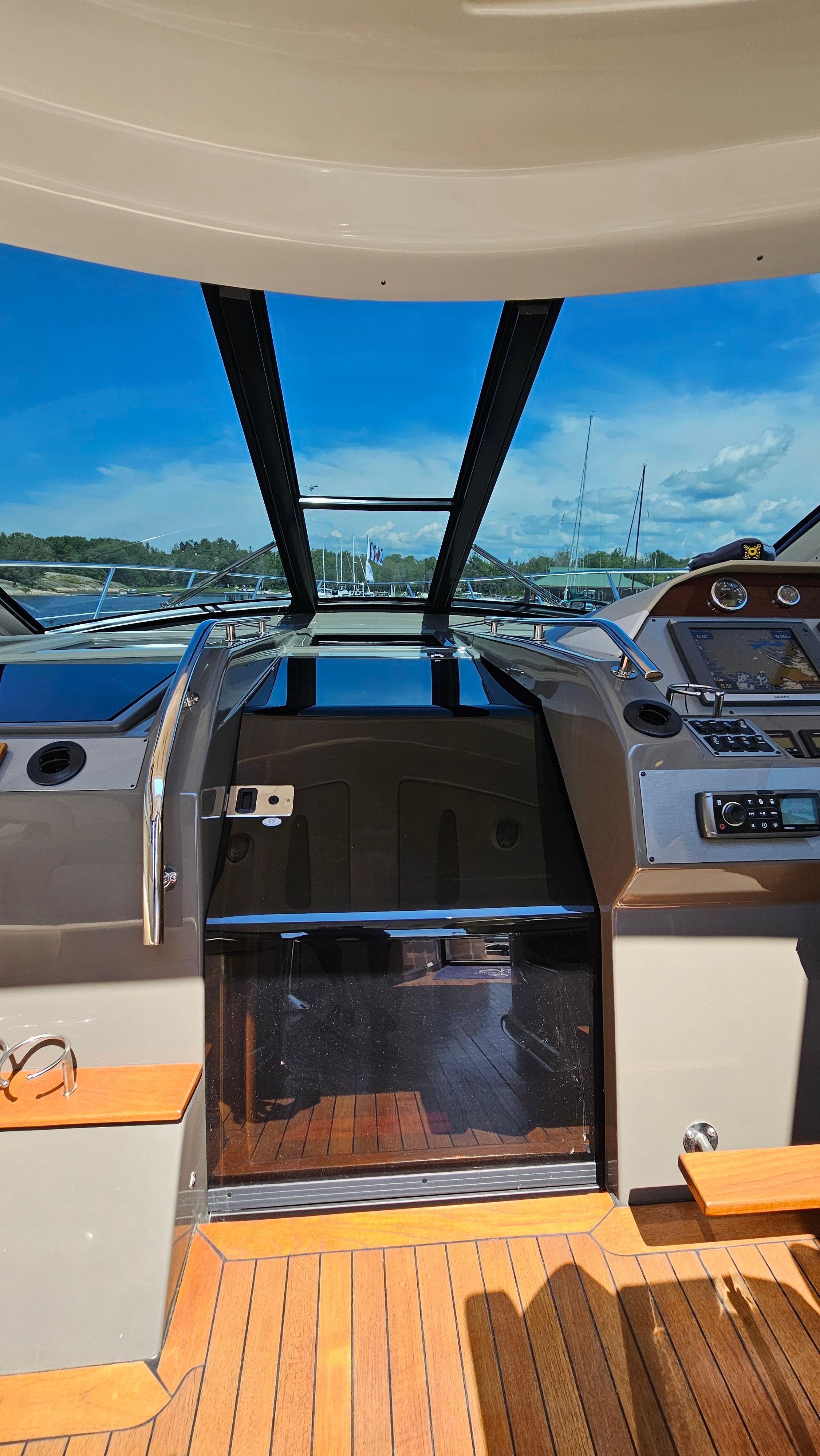 Interior view of 2012 Regal 52 Sport Coupe yacht with open sunroof and wooden flooring.