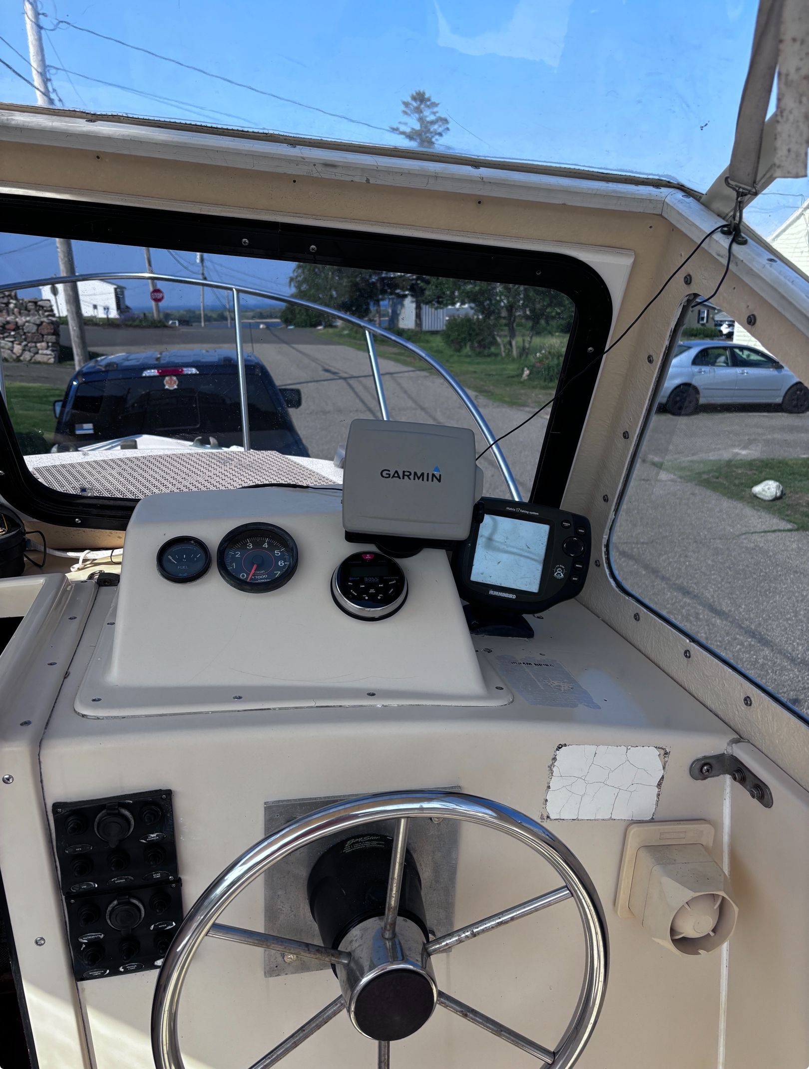 The image shows the helm of a 1984 SISU 22’ Bass boat with a Garmin navigation system.