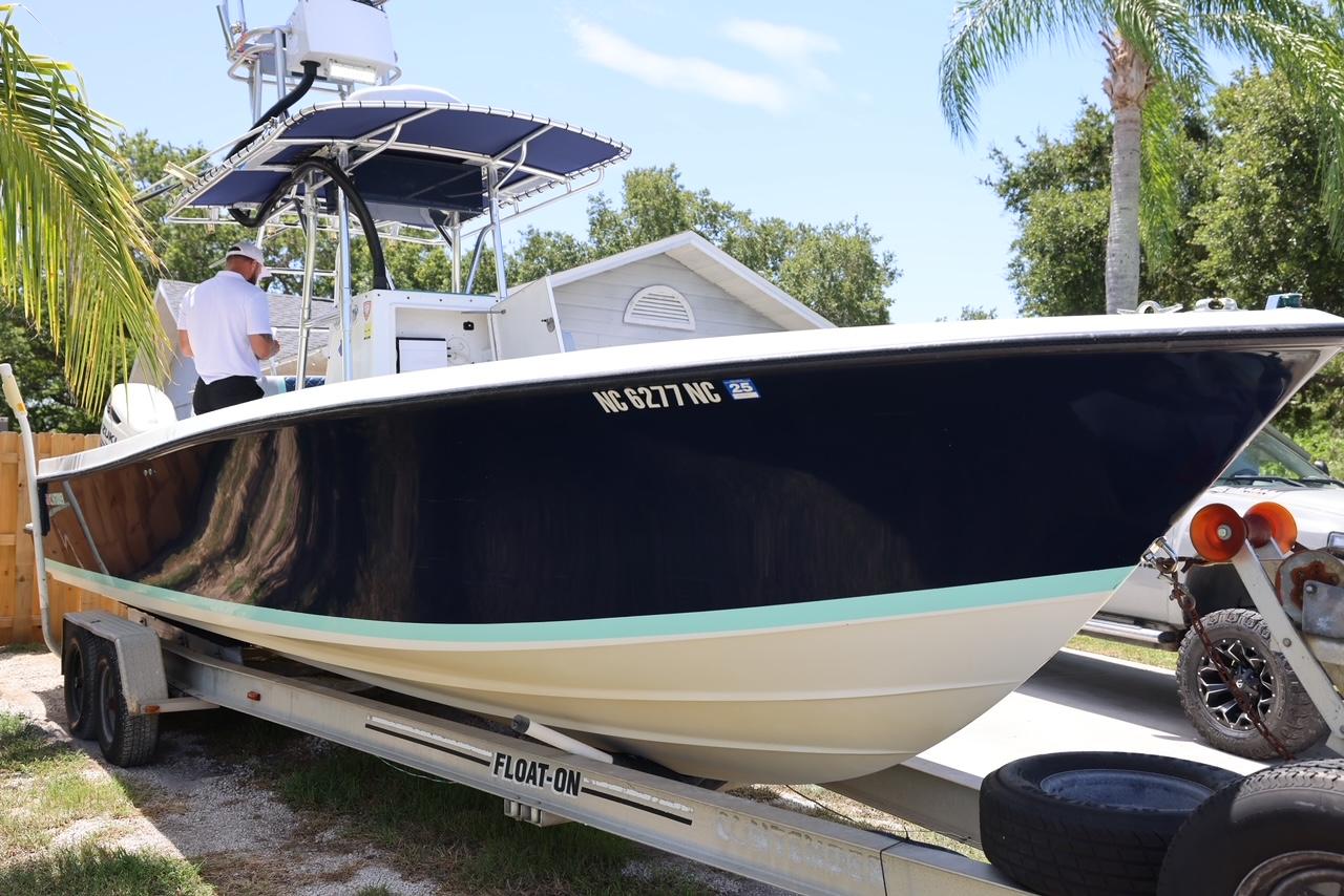 2001 Contender 27 Open boat on trailer, side view, with palm trees in background.