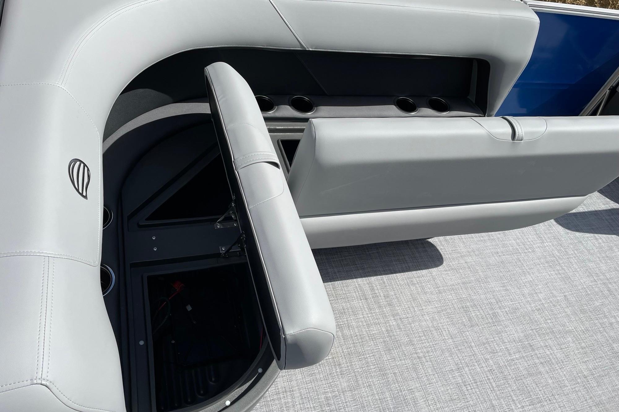 2026 Sun Tracker Party Barge 16 DLX interior with gray seating and storage compartments.