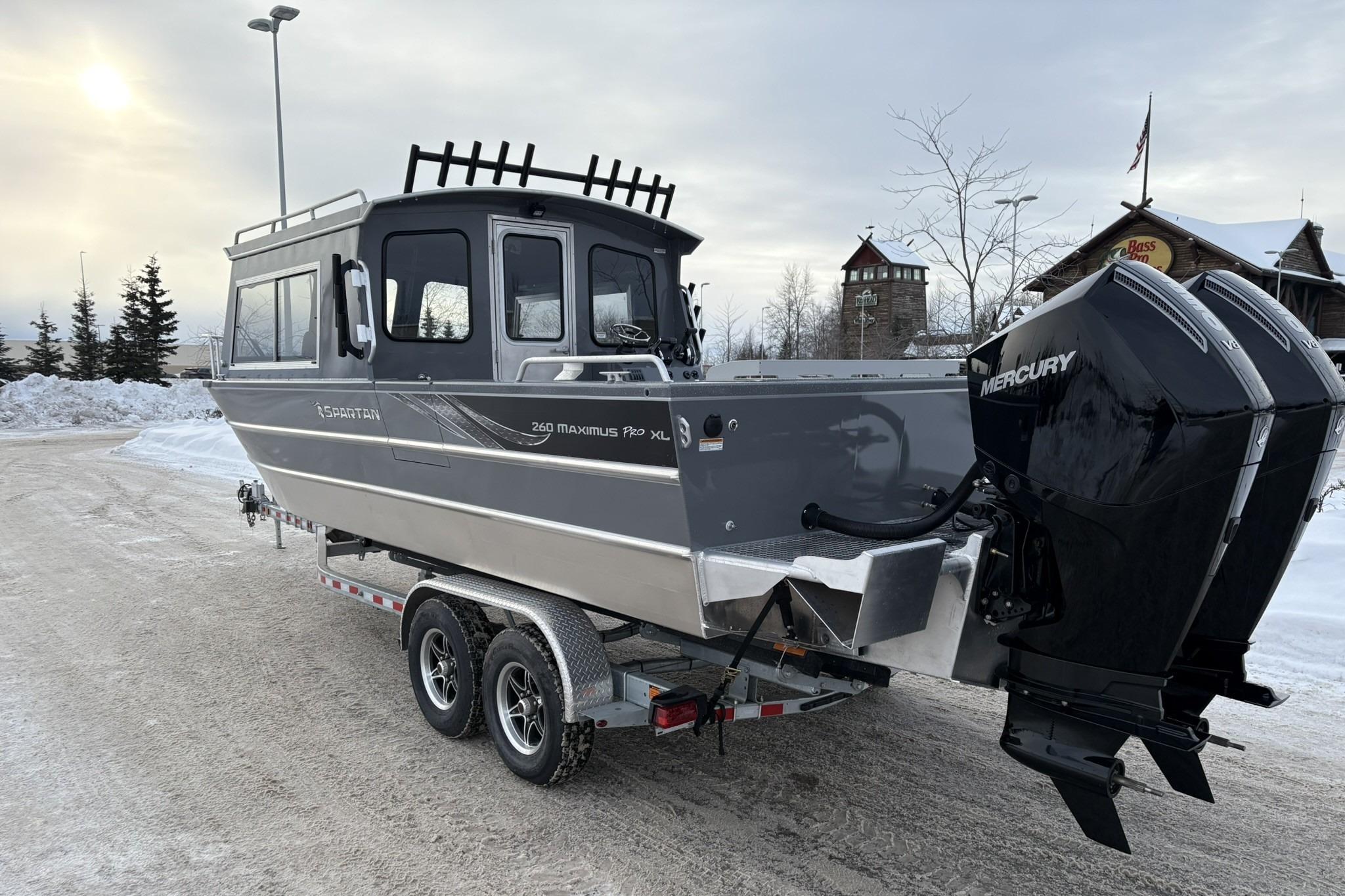 2024 Spartan 26 Maximus Pro XL boat on trailer with dual Mercury engines in snowy setting.