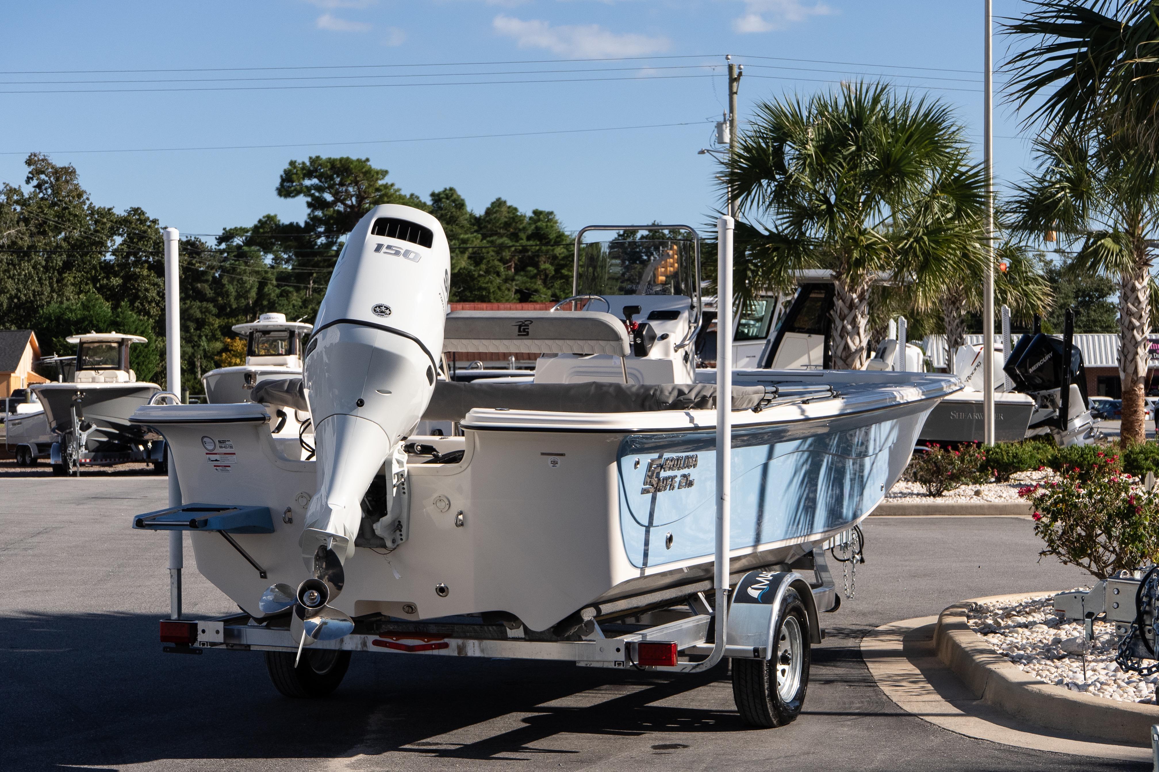 2026 Carolina Skiff 21 LS boat on trailer, parked outdoors with palm trees.