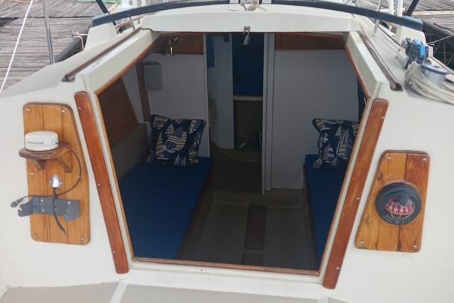 Interior view of a 1989 O'Day 272 sailboat with blue cushions and nautical decor.
