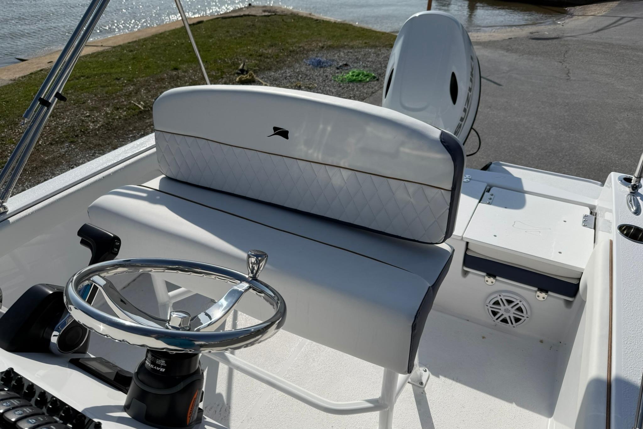 2026 Stingray 173 CC boat interior with steering wheel and seating near water.