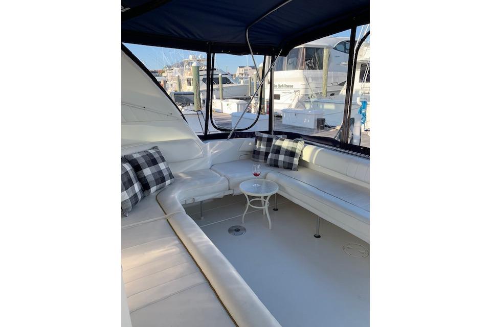 1999 Sea Ray Sundancer 400 yacht interior with white seating and plaid pillows.