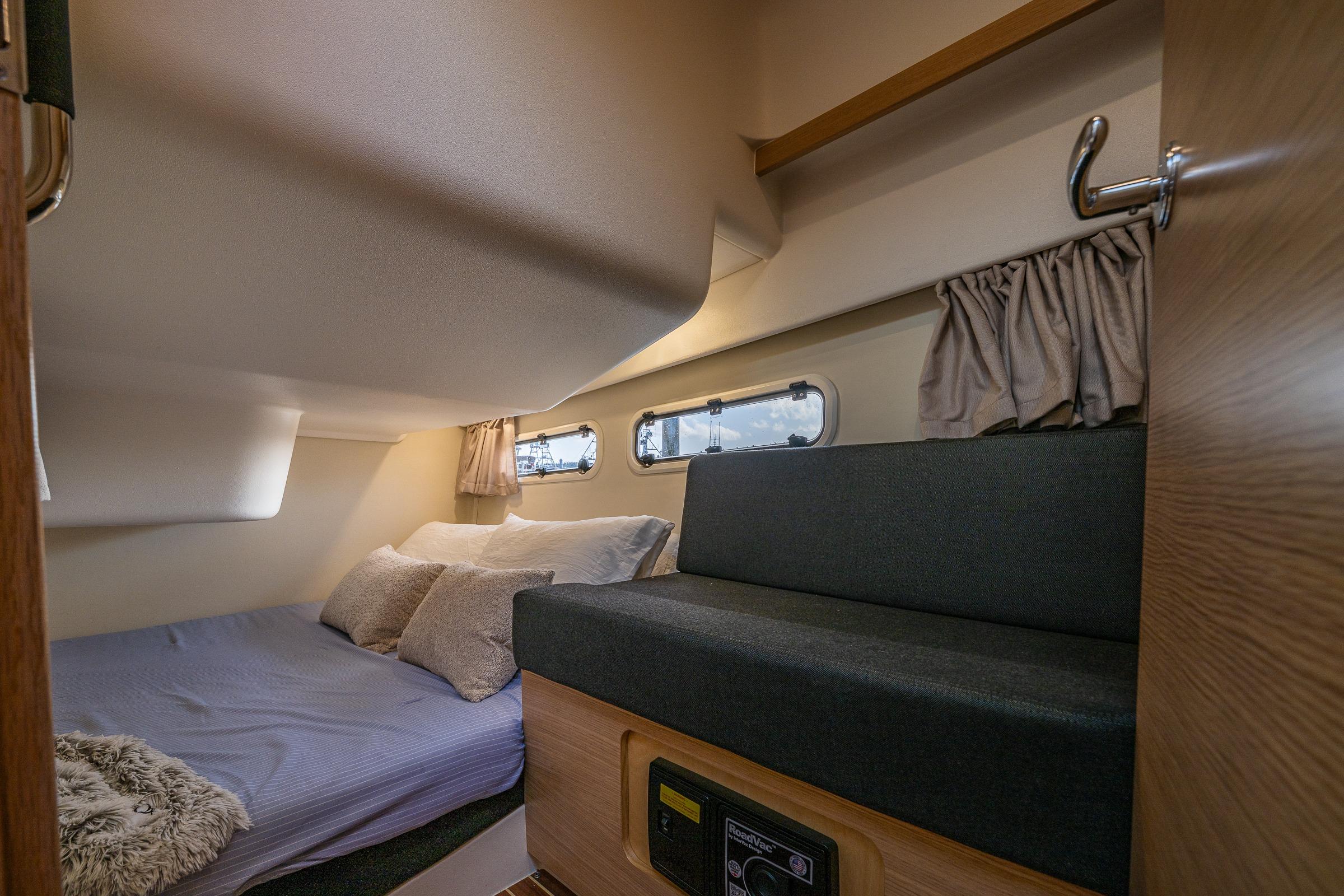 Interior cabin of 2022 Nimbus 365 Coupe, featuring cozy bed and seating area.