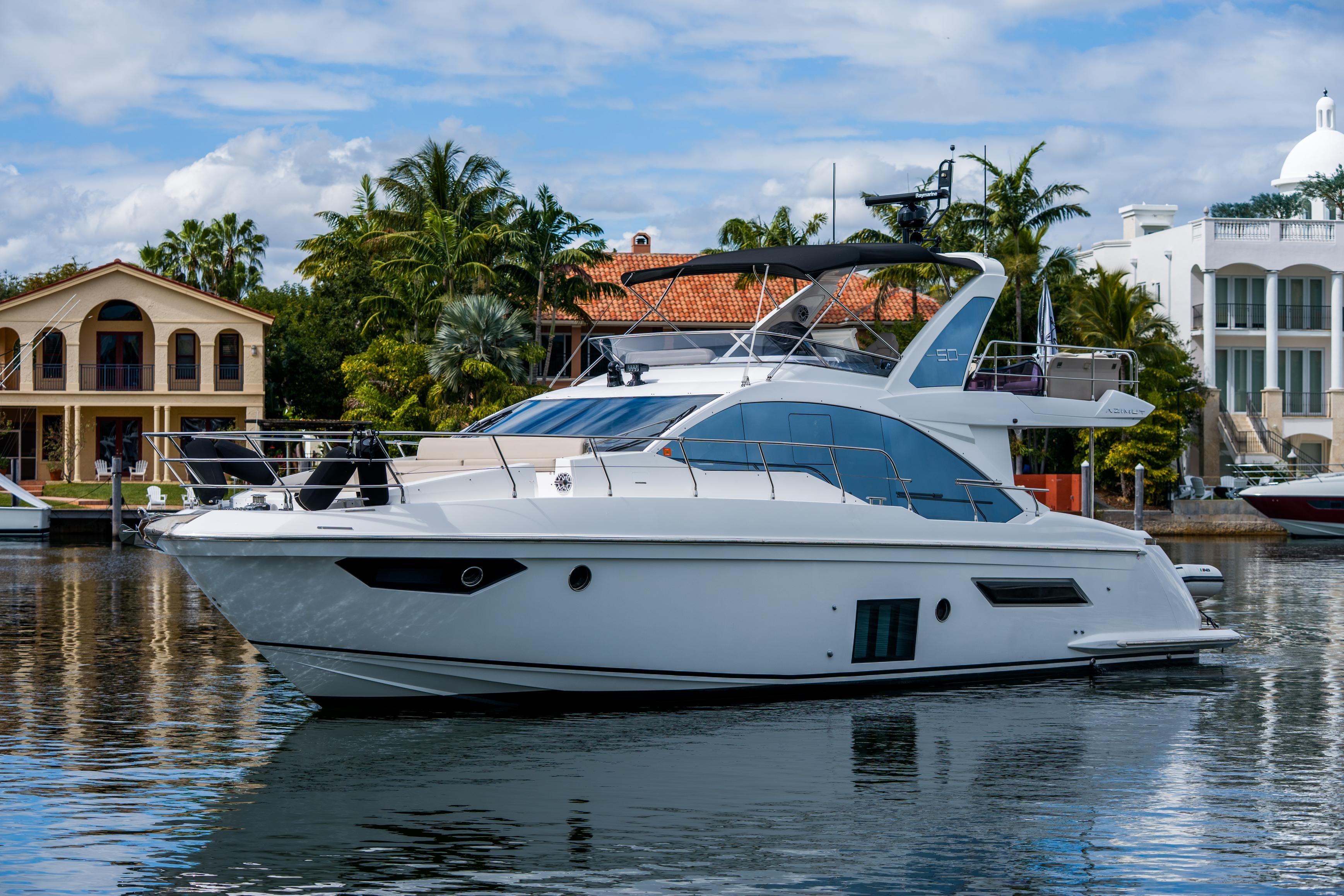 2019 Azimut Fly 50 yacht docked near luxury waterfront homes.