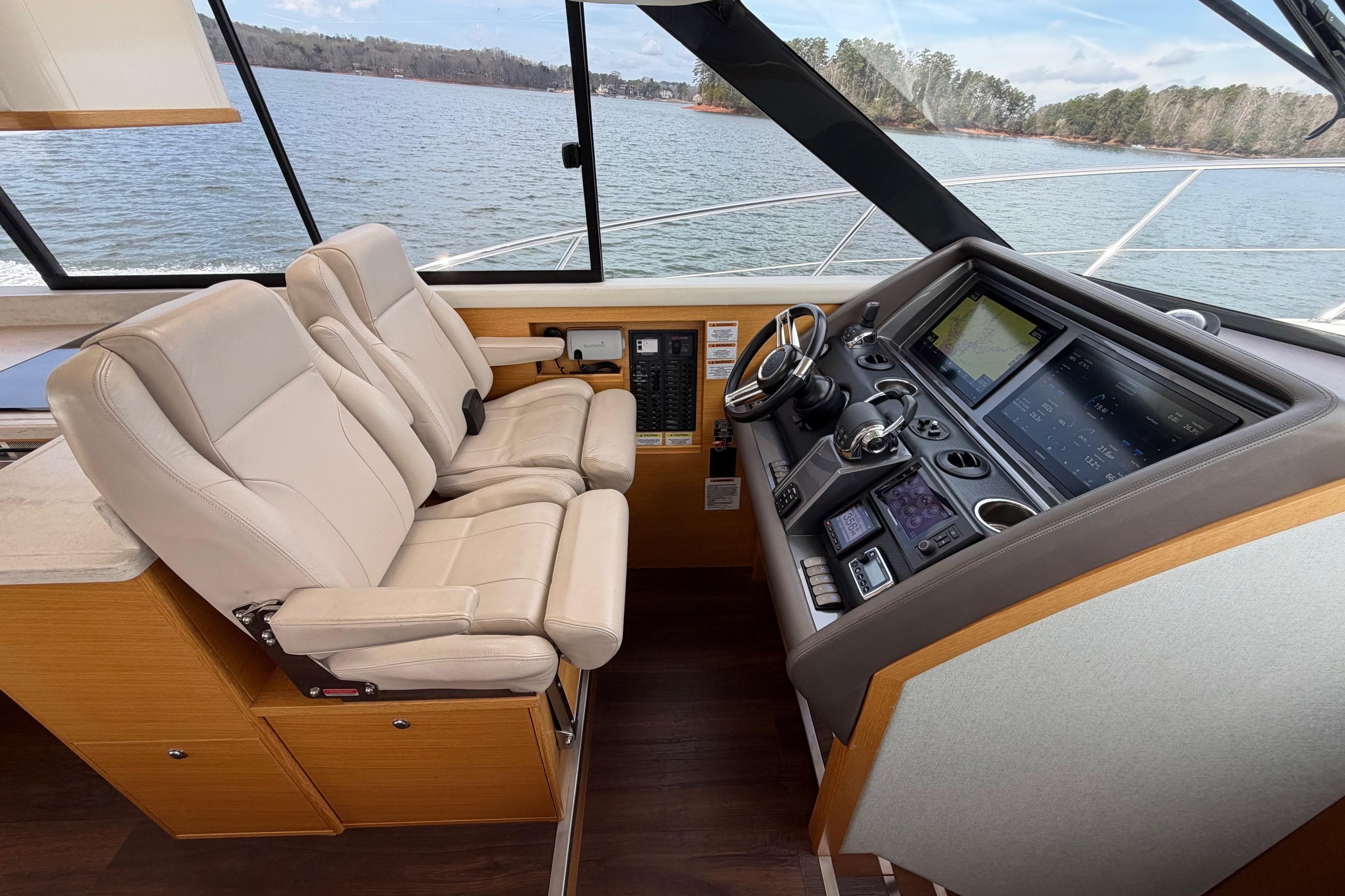 Interior of 2016 Riviera 445 SUV yacht with modern helm and dual leather seats.