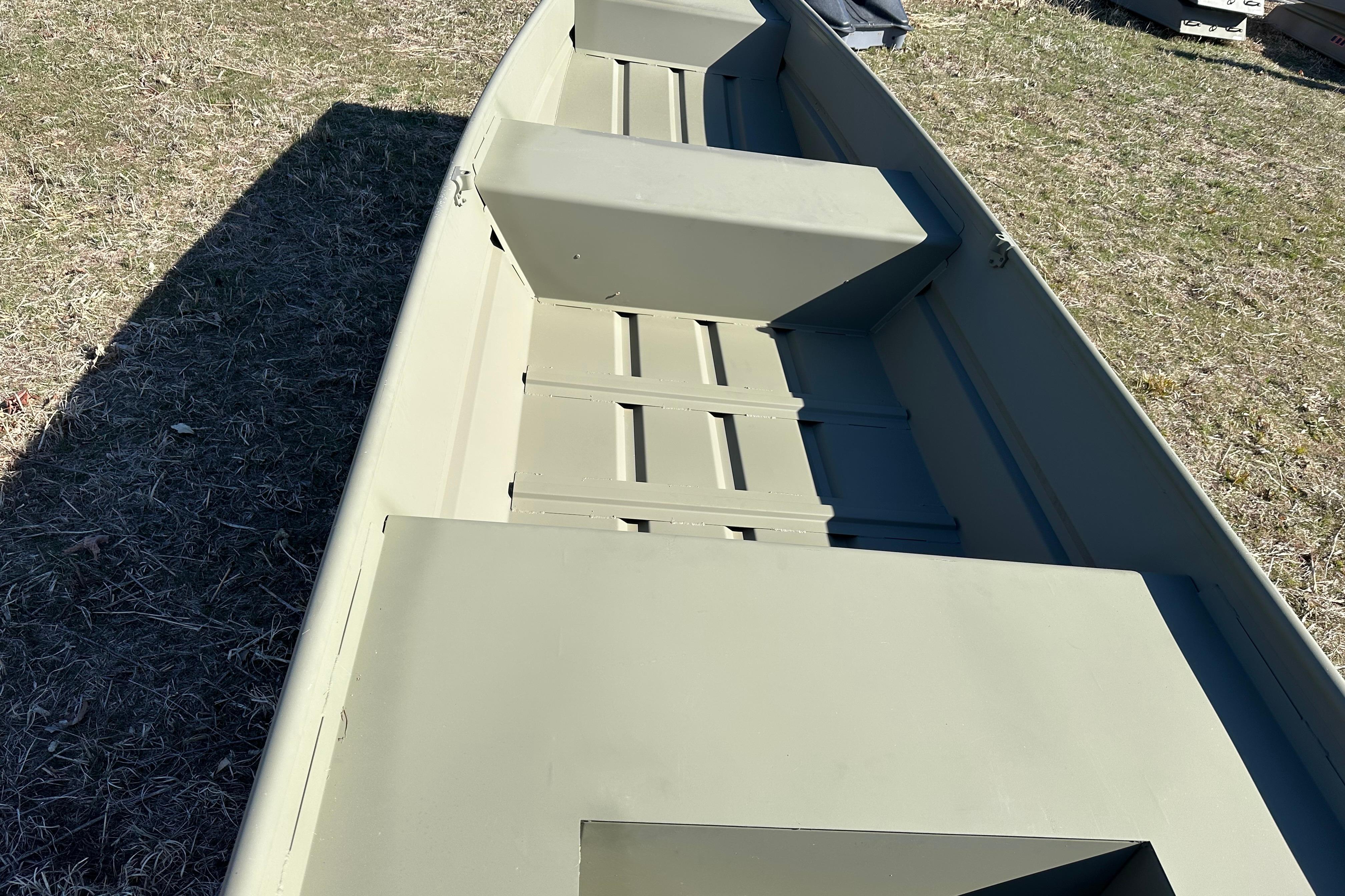 2026 Tracker Grizzly 14 Jon boat on grass, showcasing interior seating and structure.