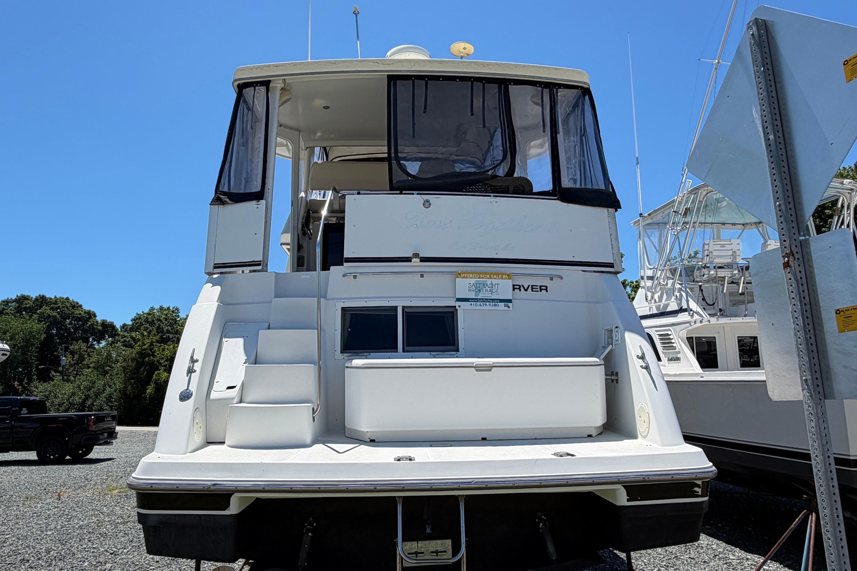 1995 Carver 356 Aft Cabin Motor Yacht, docked, rear view, clear sky background.