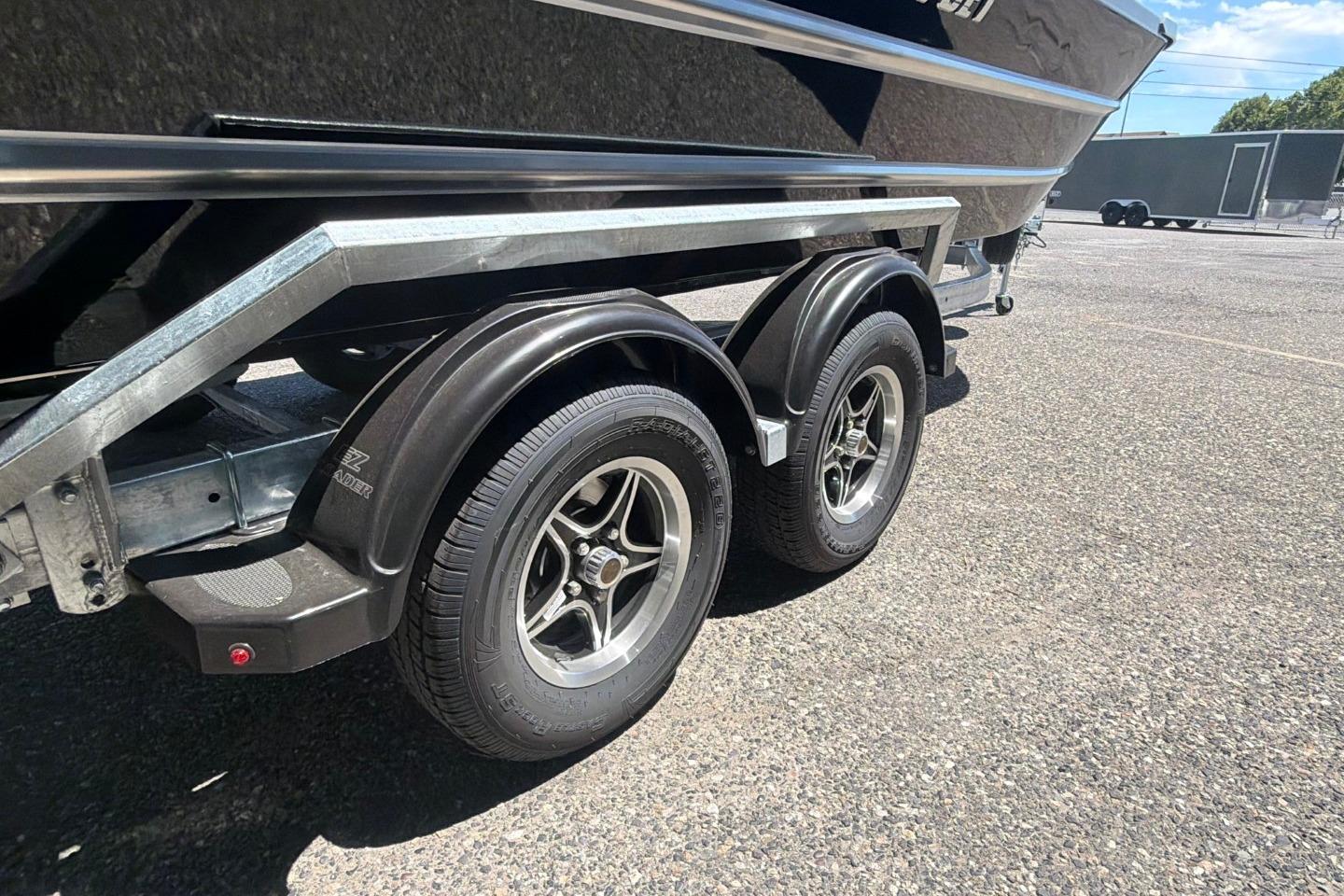 Trailer of 2026 Thunder Jet 209 Rush OT boat with dual wheels on pavement.