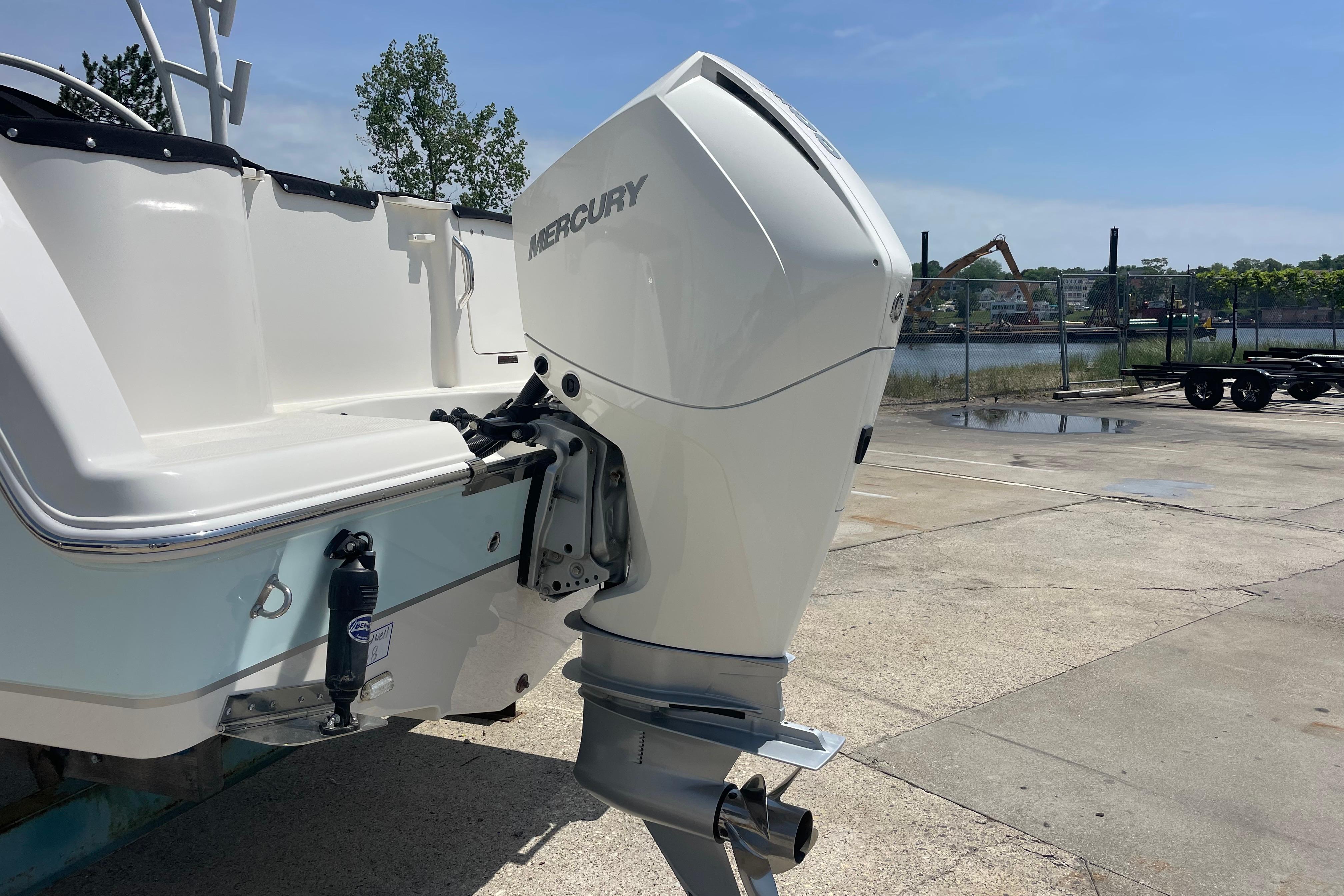2022 Sailfish 245 DC boat with Mercury outboard motor, docked on a sunny day.