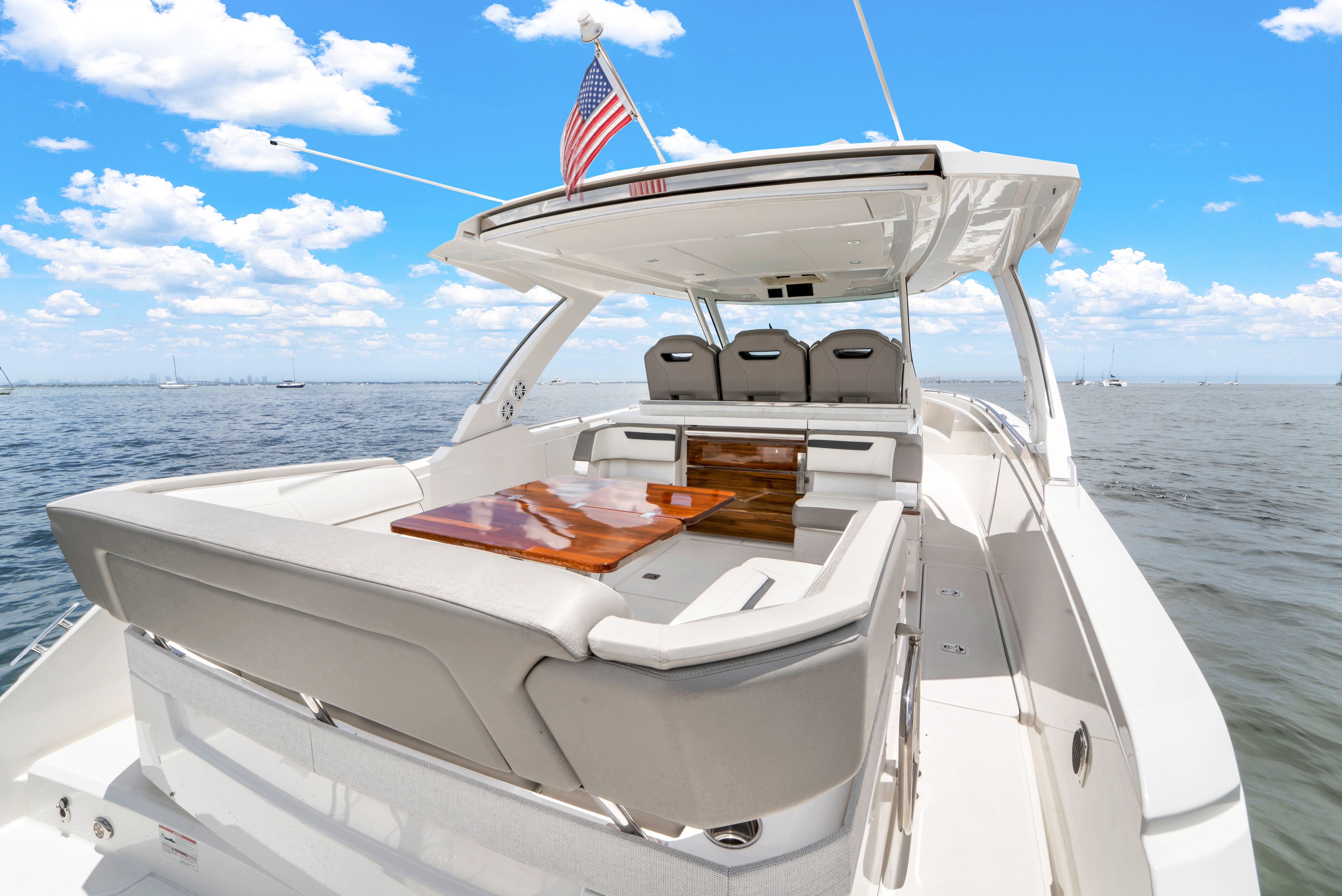 Tiara Yachts 38 LS 2023 on the water with a luxurious deck and American flag.