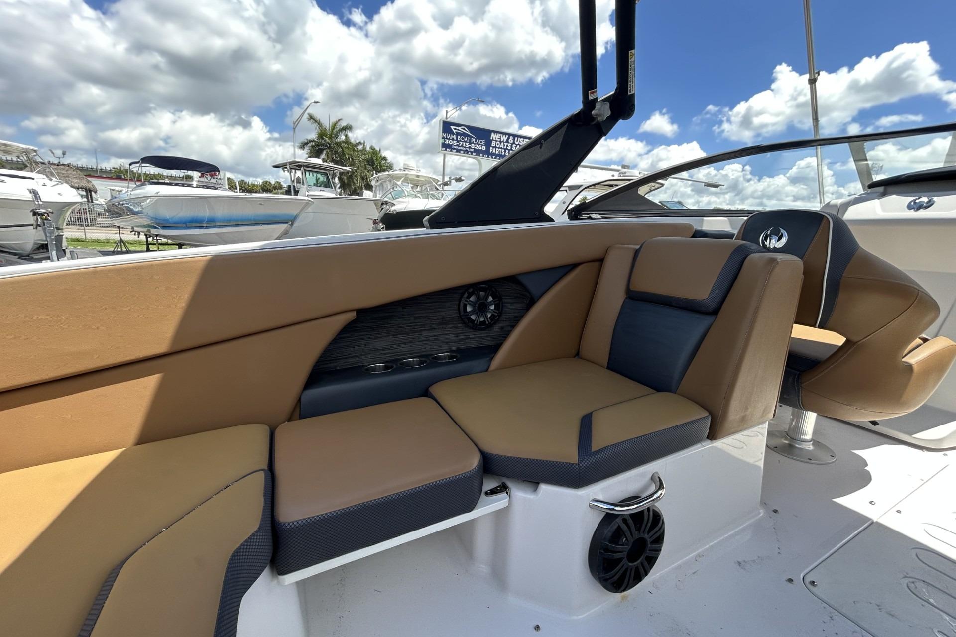 2019 Scarab 255 ID boat interior with tan and black seating under a blue sky.