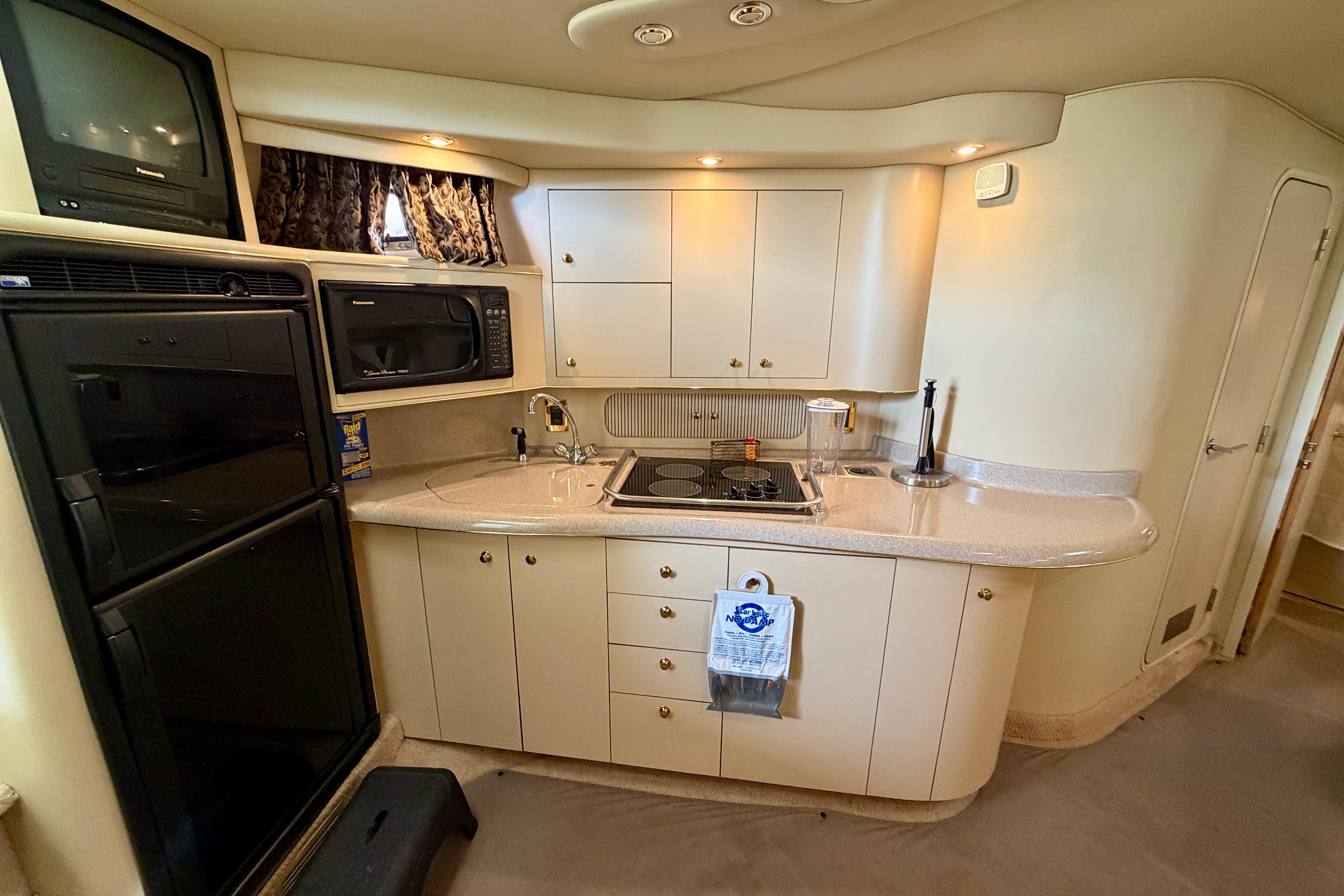 1999 Sea Ray 400 Sundancer yacht kitchen with appliances and cabinetry.