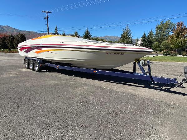 2002 Advantage Victory boat on trailer, parked outdoors, clear sky, trees in background.