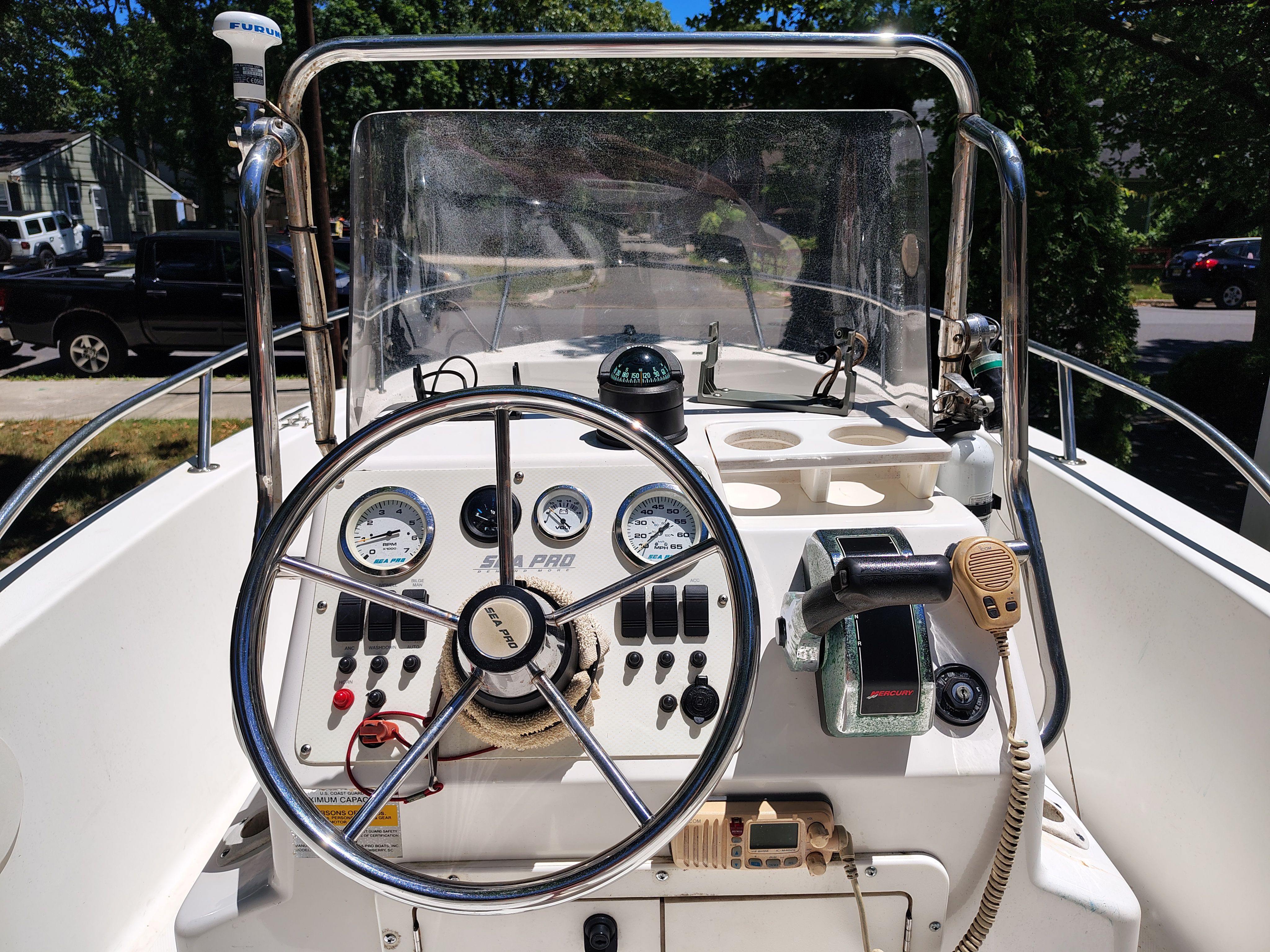 2003 Sea Pro 180 Center Console helm with steering wheel, gauges, and microphone.
