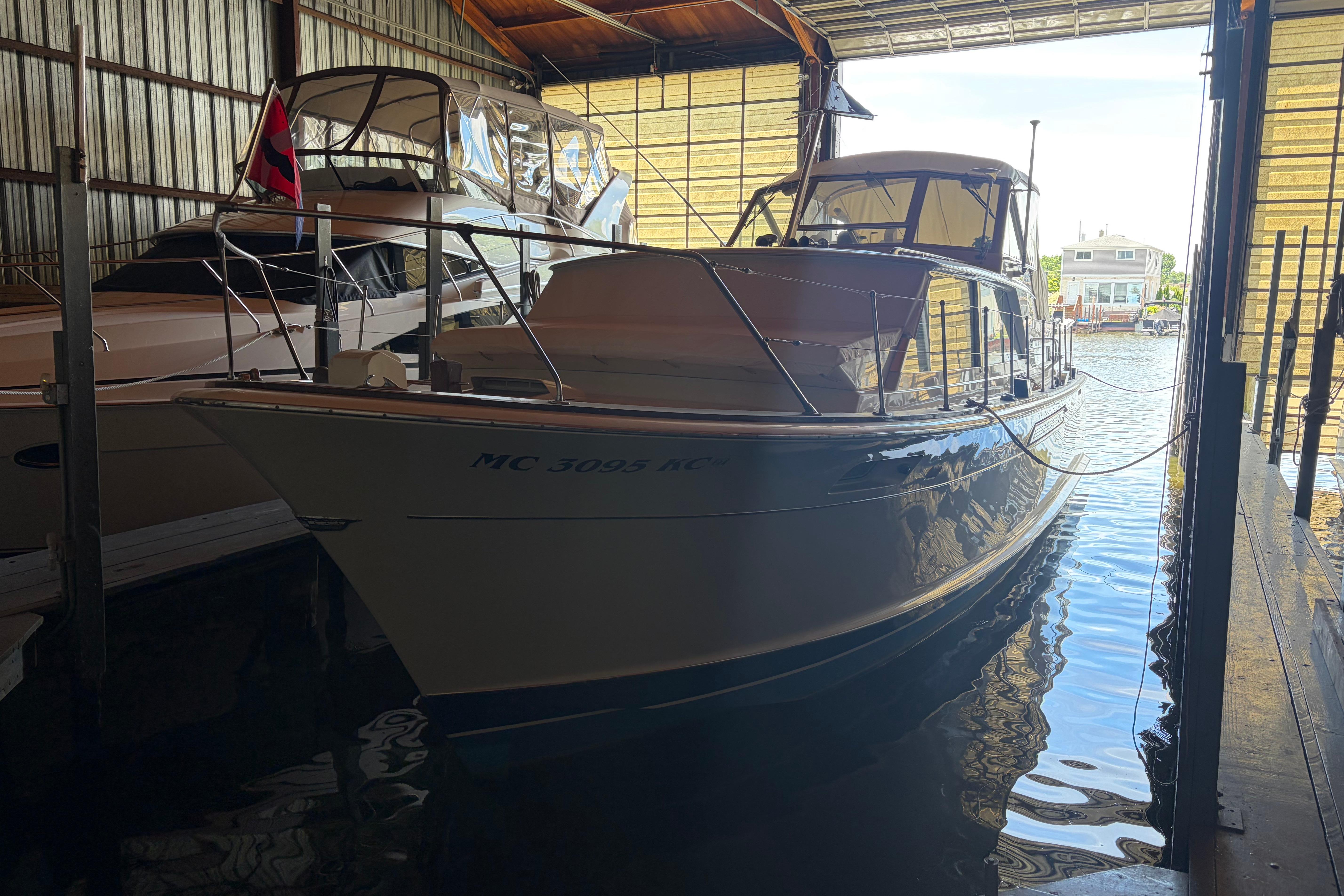 1971 Chris-Craft 42 Commander yacht docked in a marina boathouse.