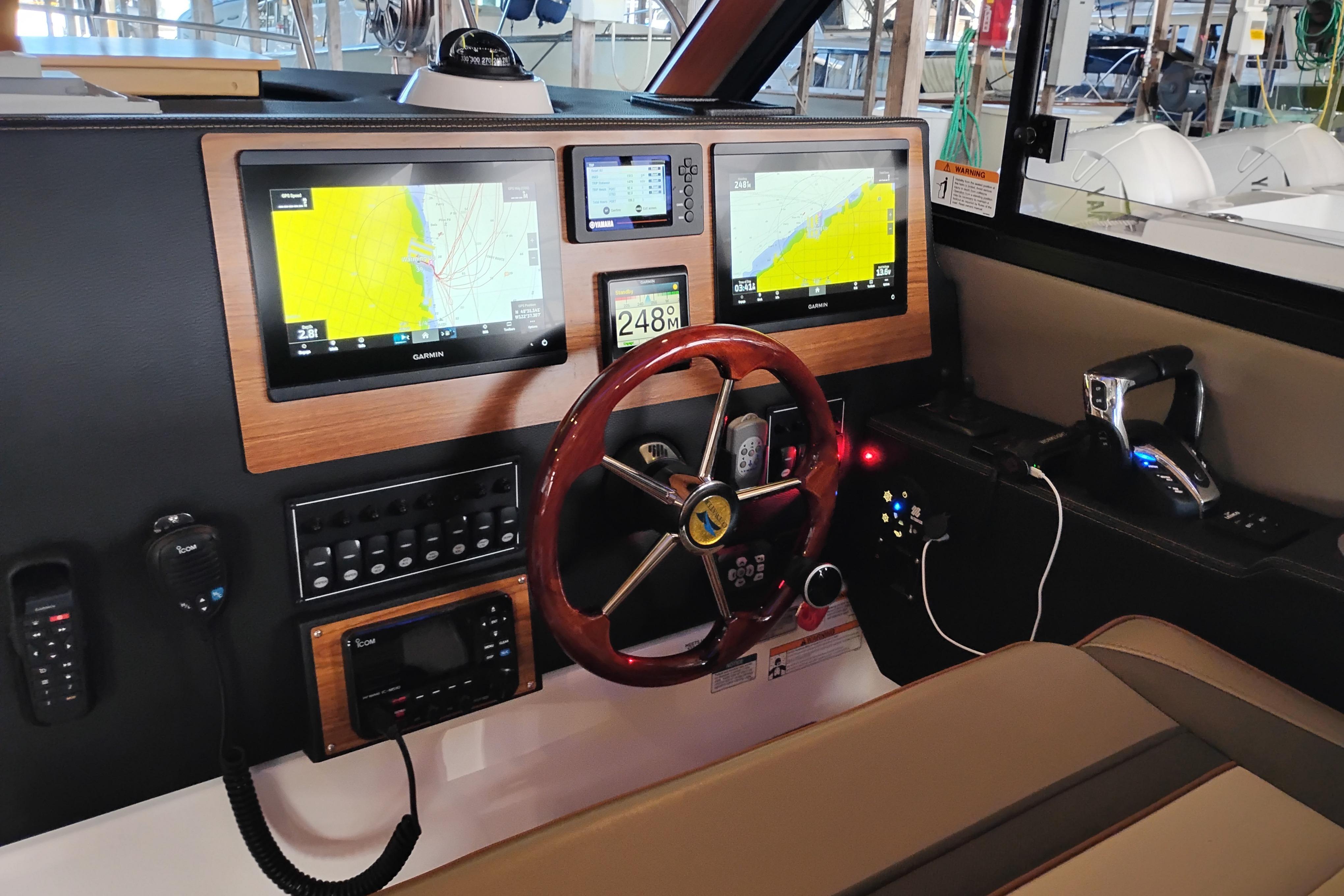 2022 Cutwater C-32 Coupe helm with dual Garmin displays and wooden steering wheel.