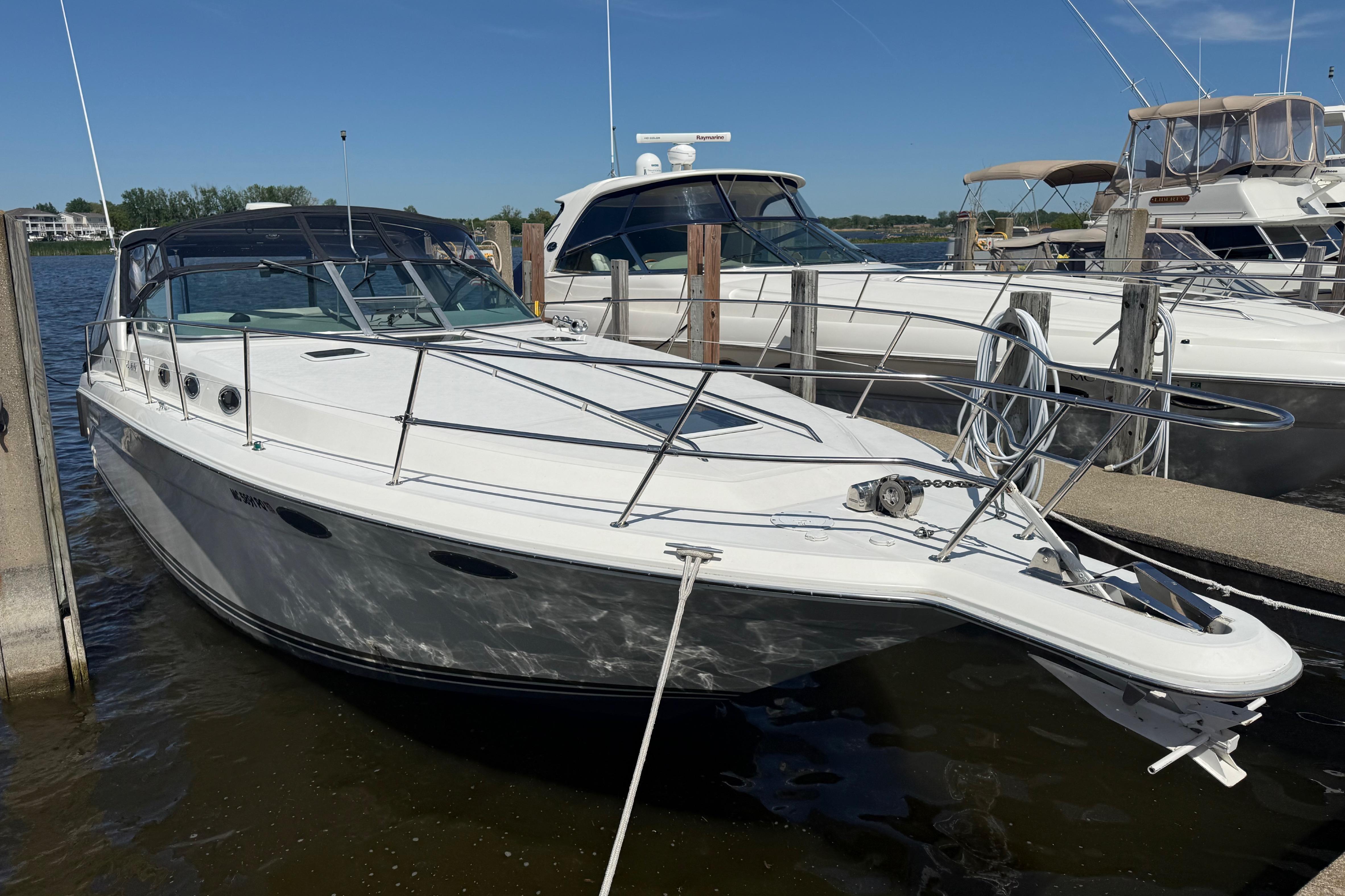 1994 Sea Ray 370 Express Cruiser docked at marina under clear blue sky.
