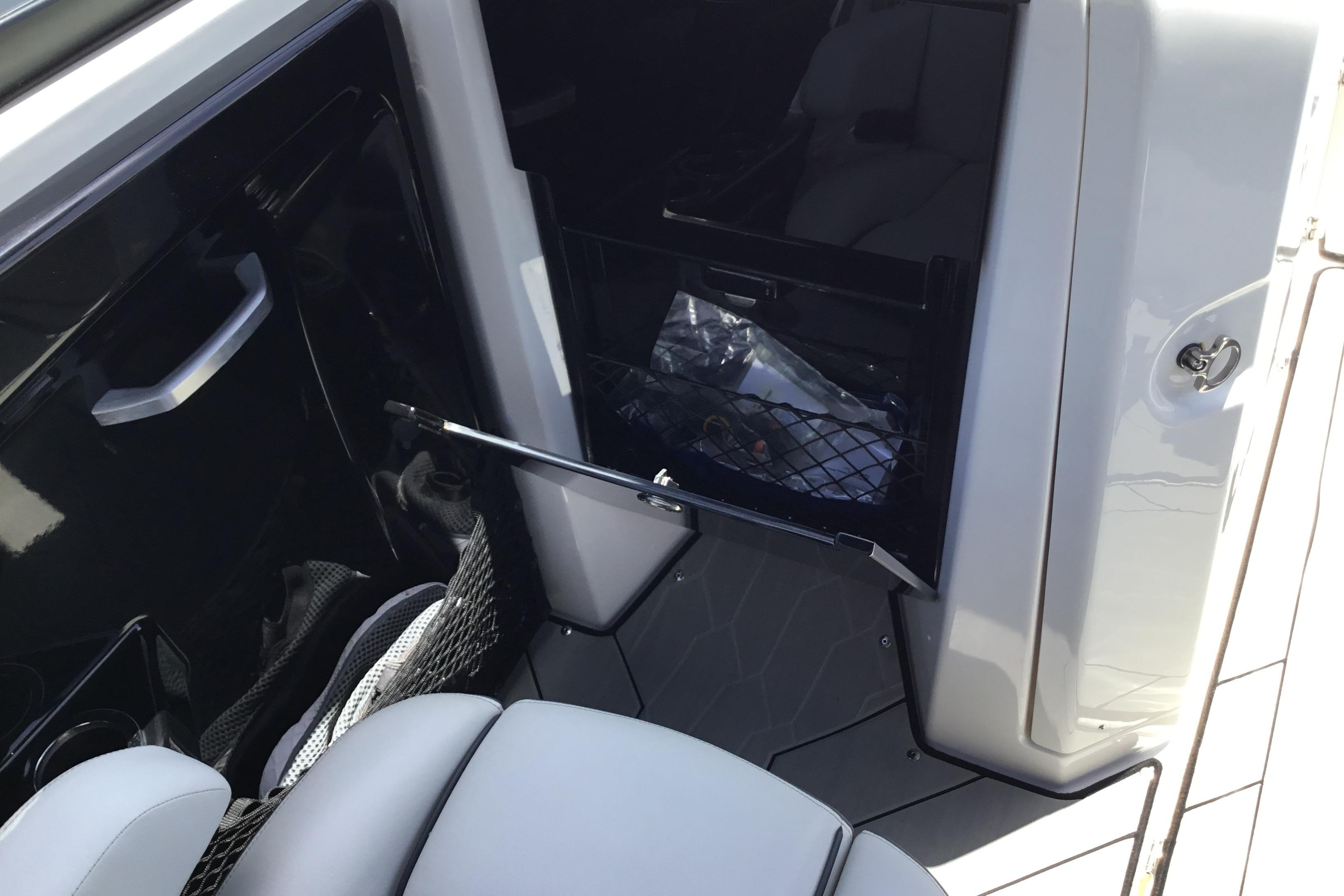 2023 Yamaha Boats 252XE interior storage compartment with open door and seating.