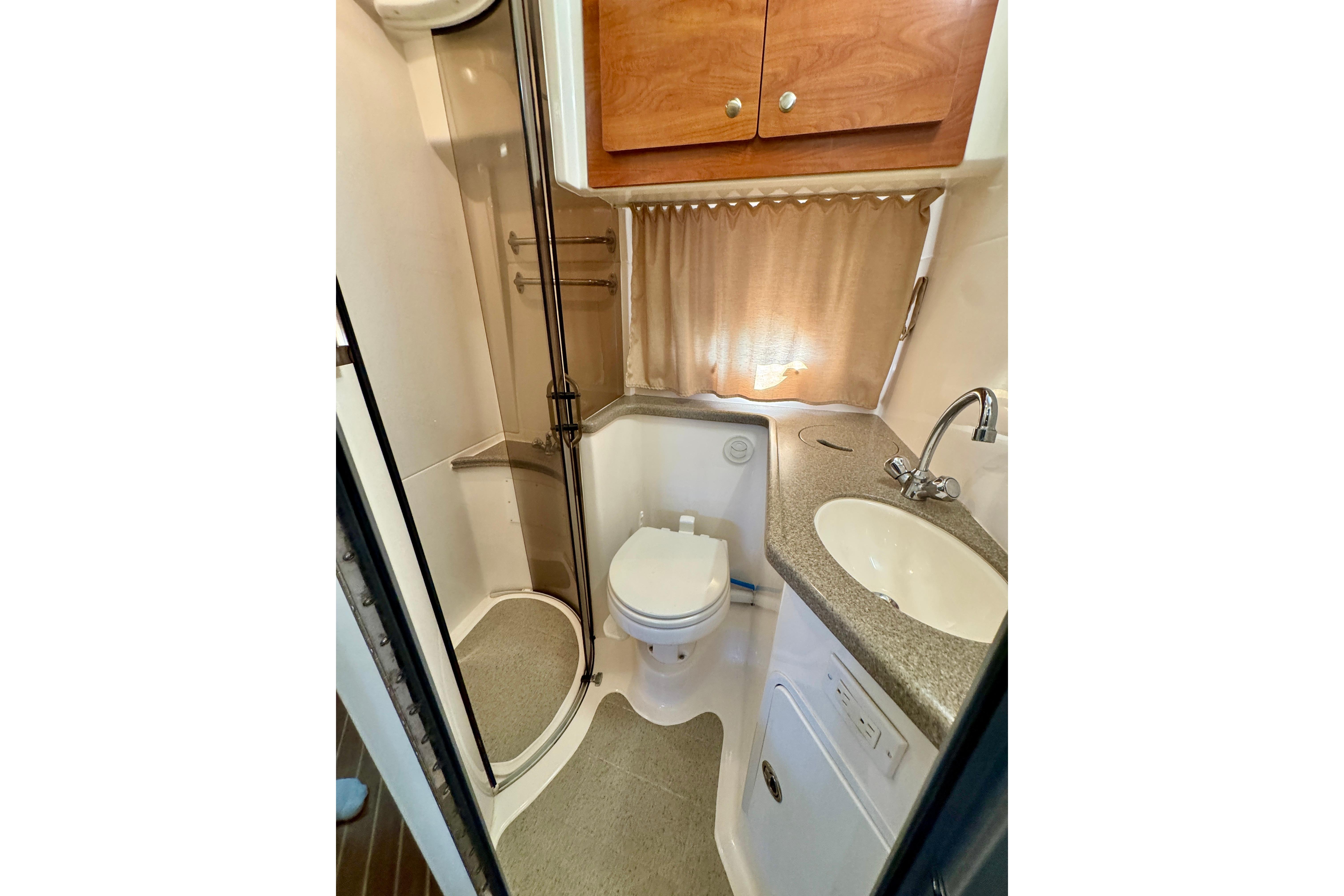 2009 Rinker 360 Express Cruiser bathroom with shower, sink, and toilet.