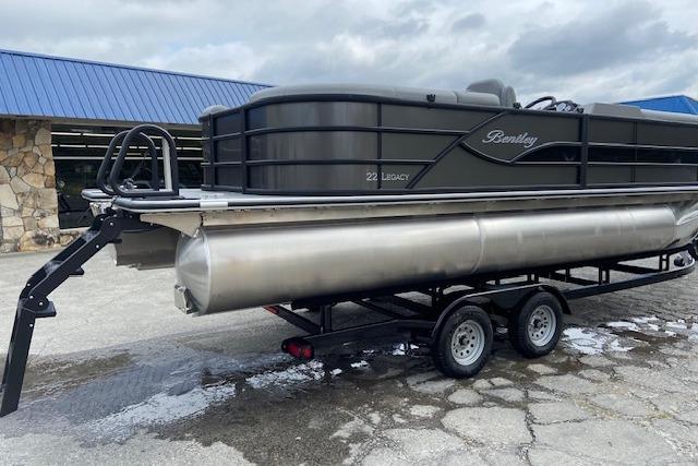 2025 Bentley Pontoons Legacy 220 Navigator on trailer, parked outdoors.