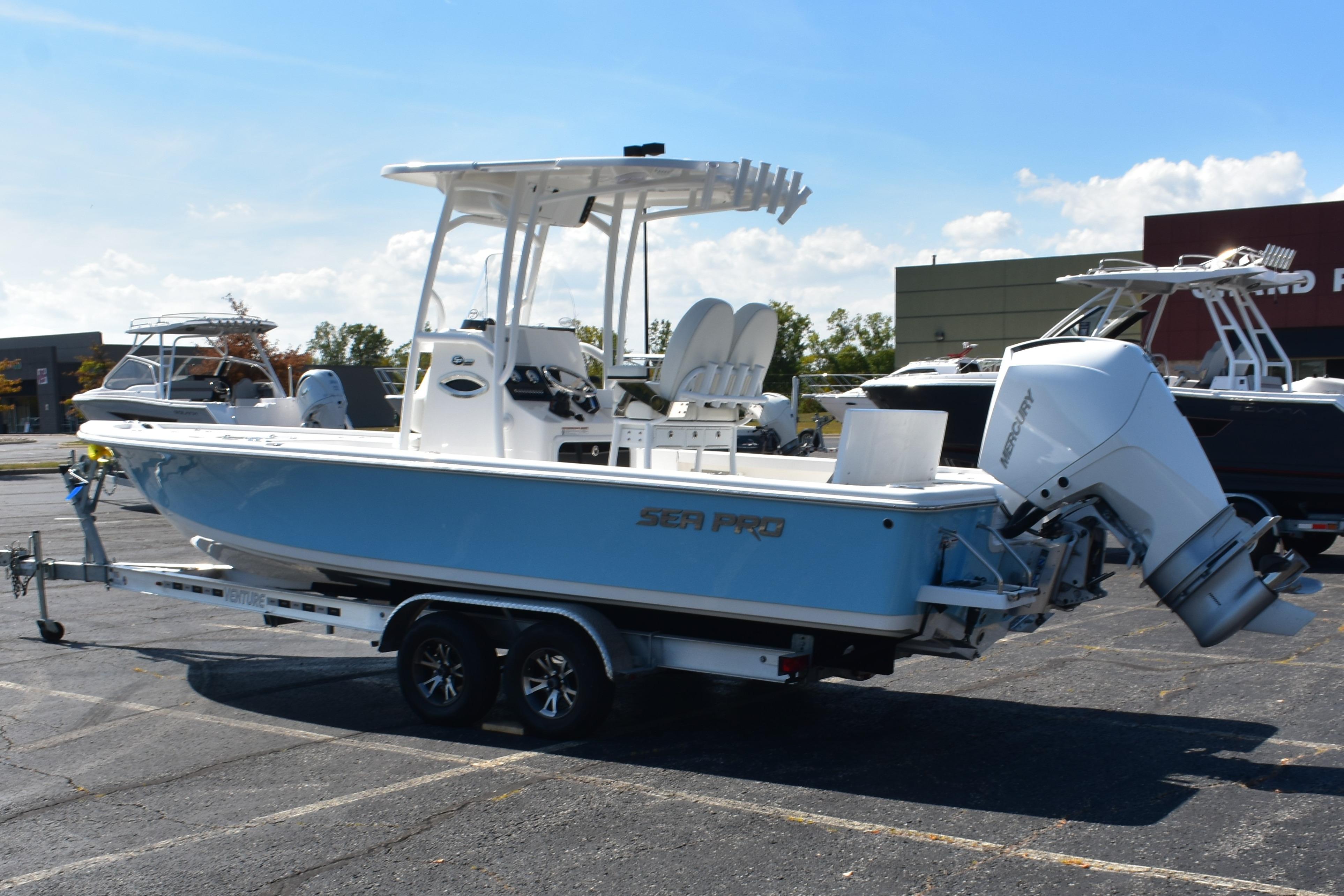 2025 Sea Pro 250 Bay boat on trailer, parked outdoors under clear sky.