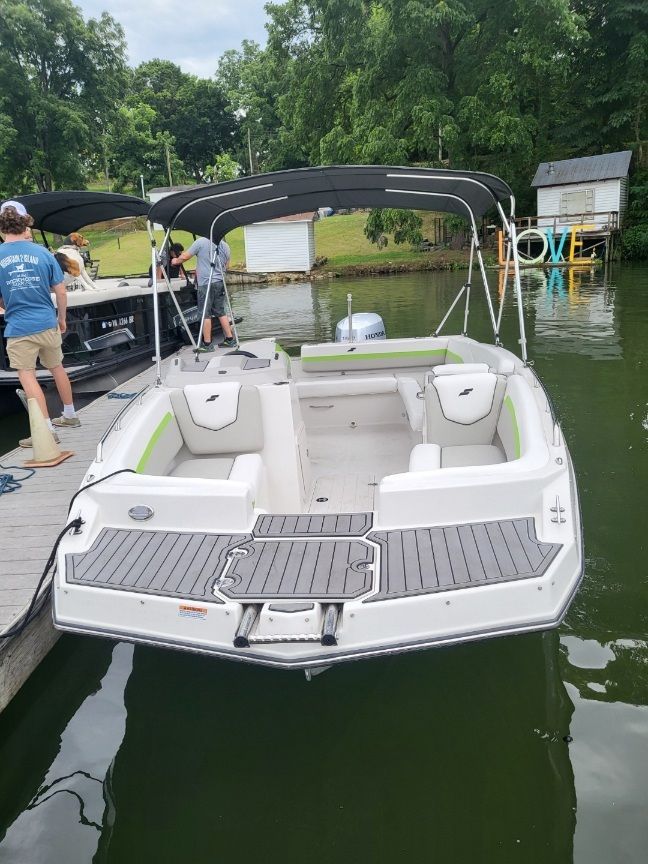 The image shows a 2023 Starcraft SVX 191 OB boat at a dock. It features an open deck with seating and a sunshade.