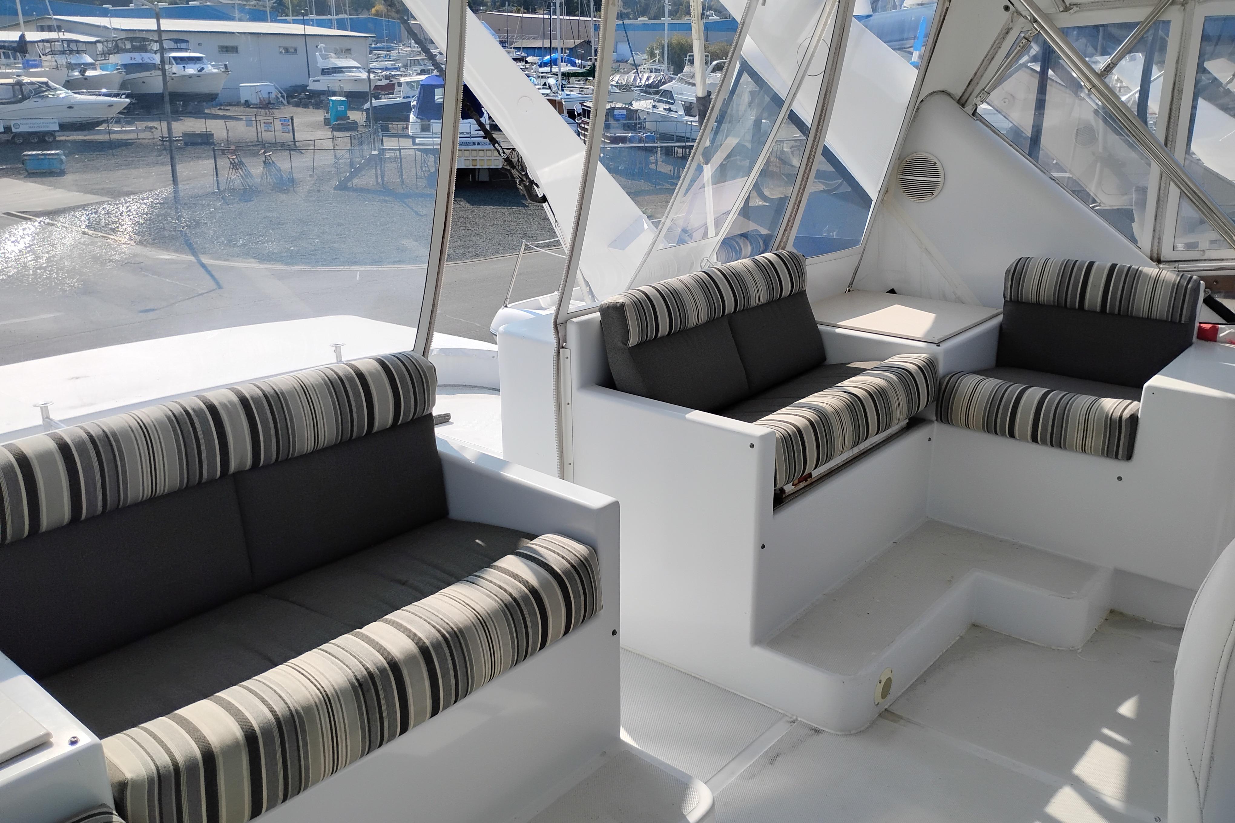 Luxurious seating area on 1995 Queenship 62 Pilothouse Motor Yacht, docked at marina.