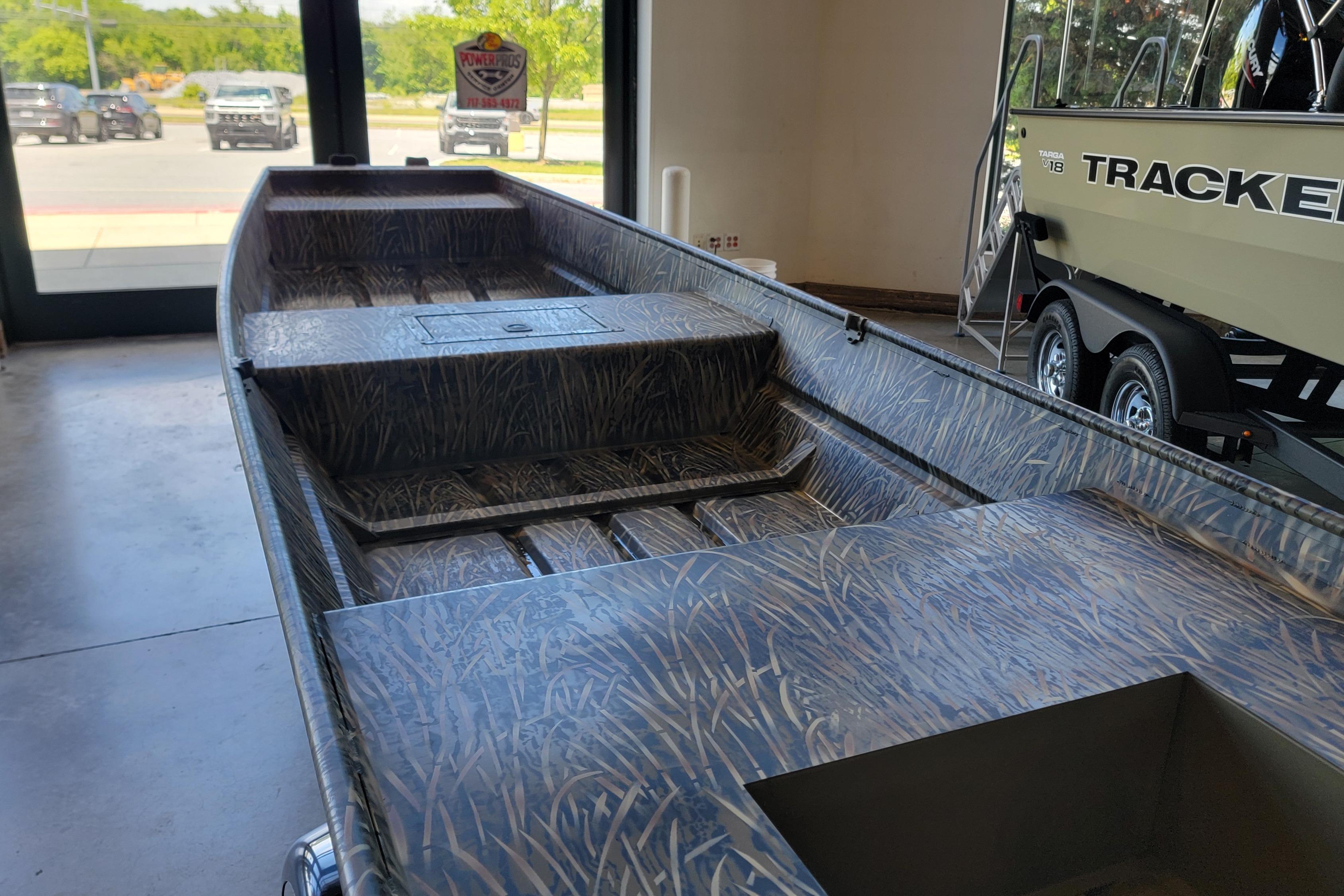 2026 Tracker Grizzly 15 Jon boat with camouflage interior, displayed indoors.