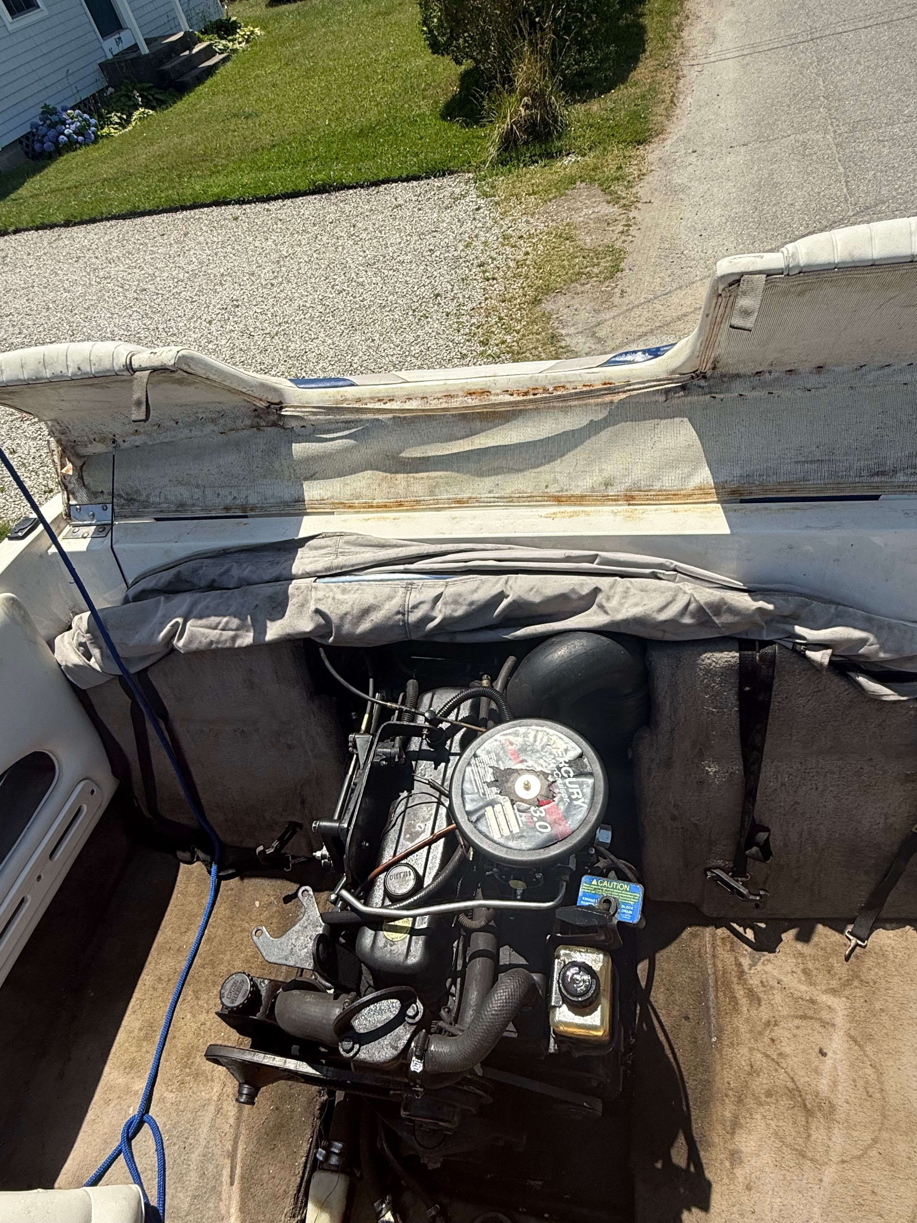 The engine compartment of a 2003 Stingray 180 LS/LX boat is visible, with an open cover.