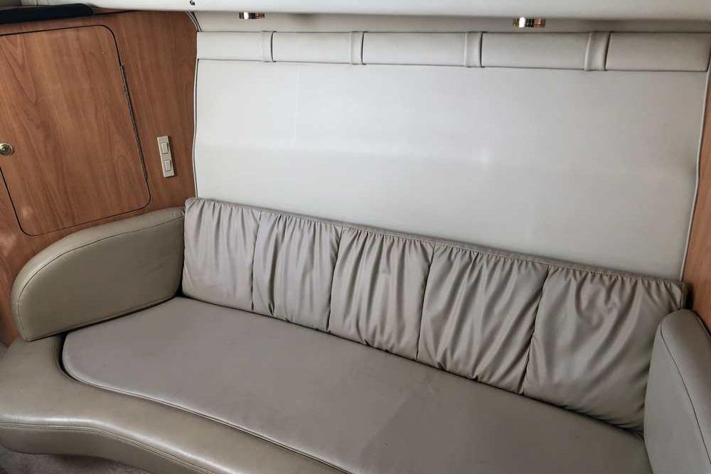 Interior of a 1999 Regal Commodore 2760 boat with beige leather seating.