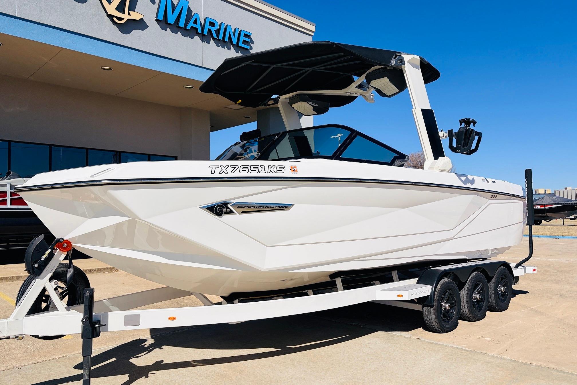 2023 Nautique Super Air Nautique G25 boat on trailer outside marine dealership.