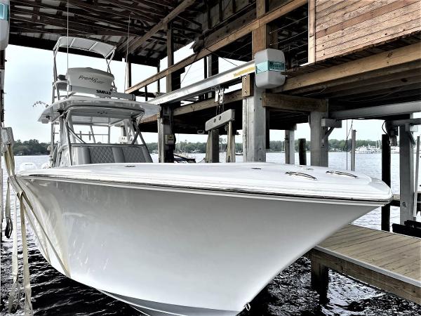 2020 Front Runner 39 Center Console boat docked under a wooden shelter.