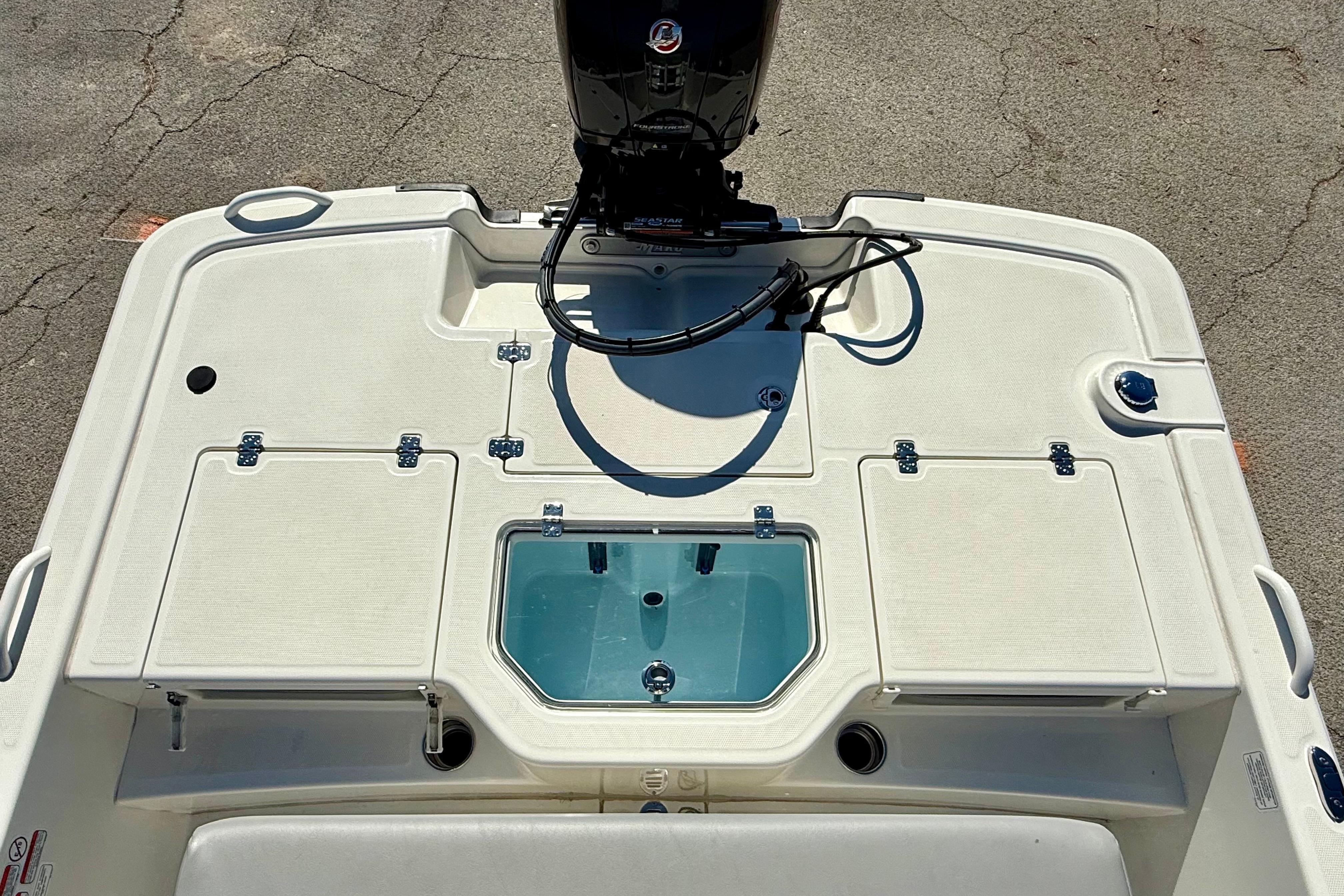 2024 Mako Pro Skiff 19 CC boat deck with storage compartments and motor.