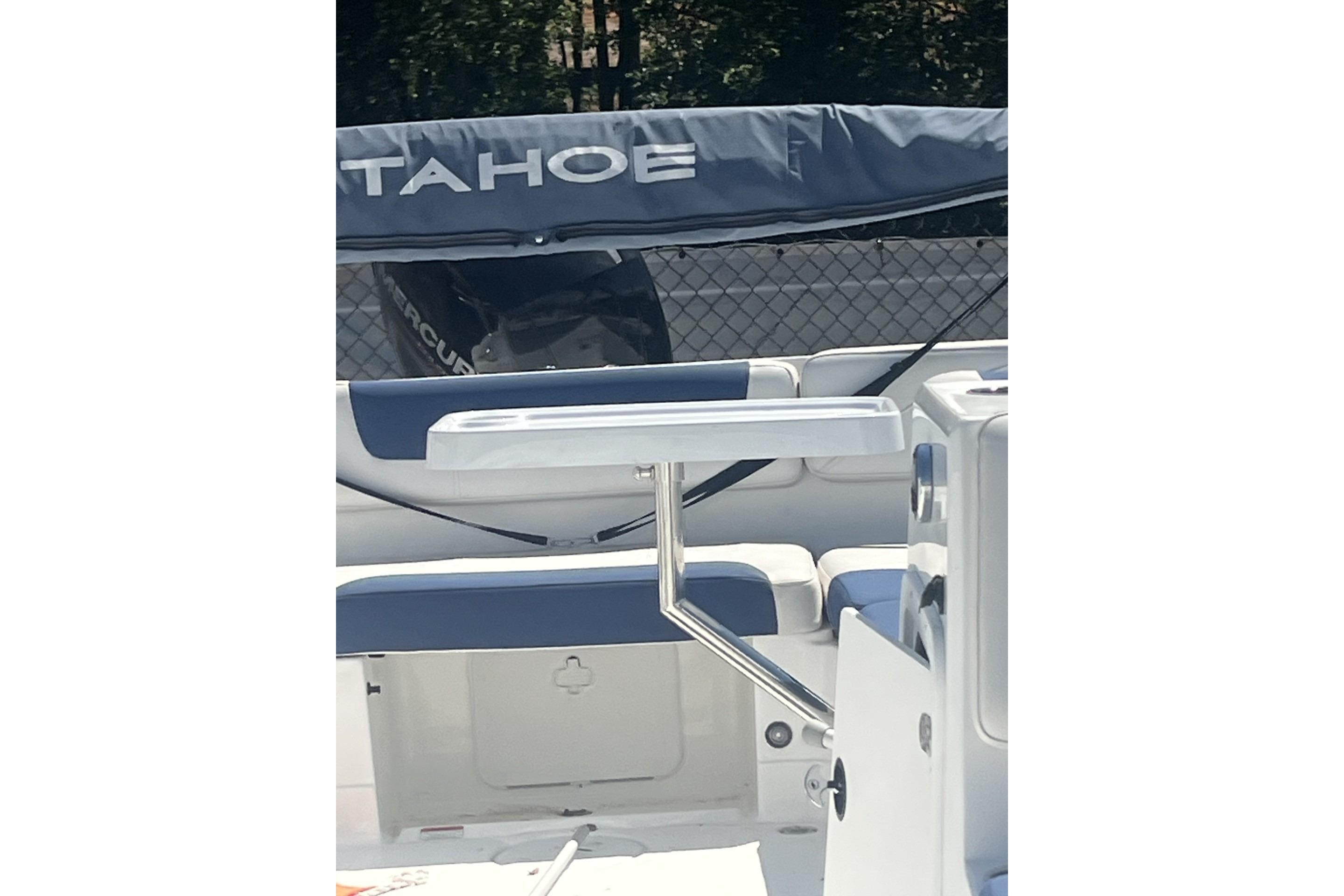 2017 Tahoe 2150 boat interior with seating and table, featuring a covered engine.