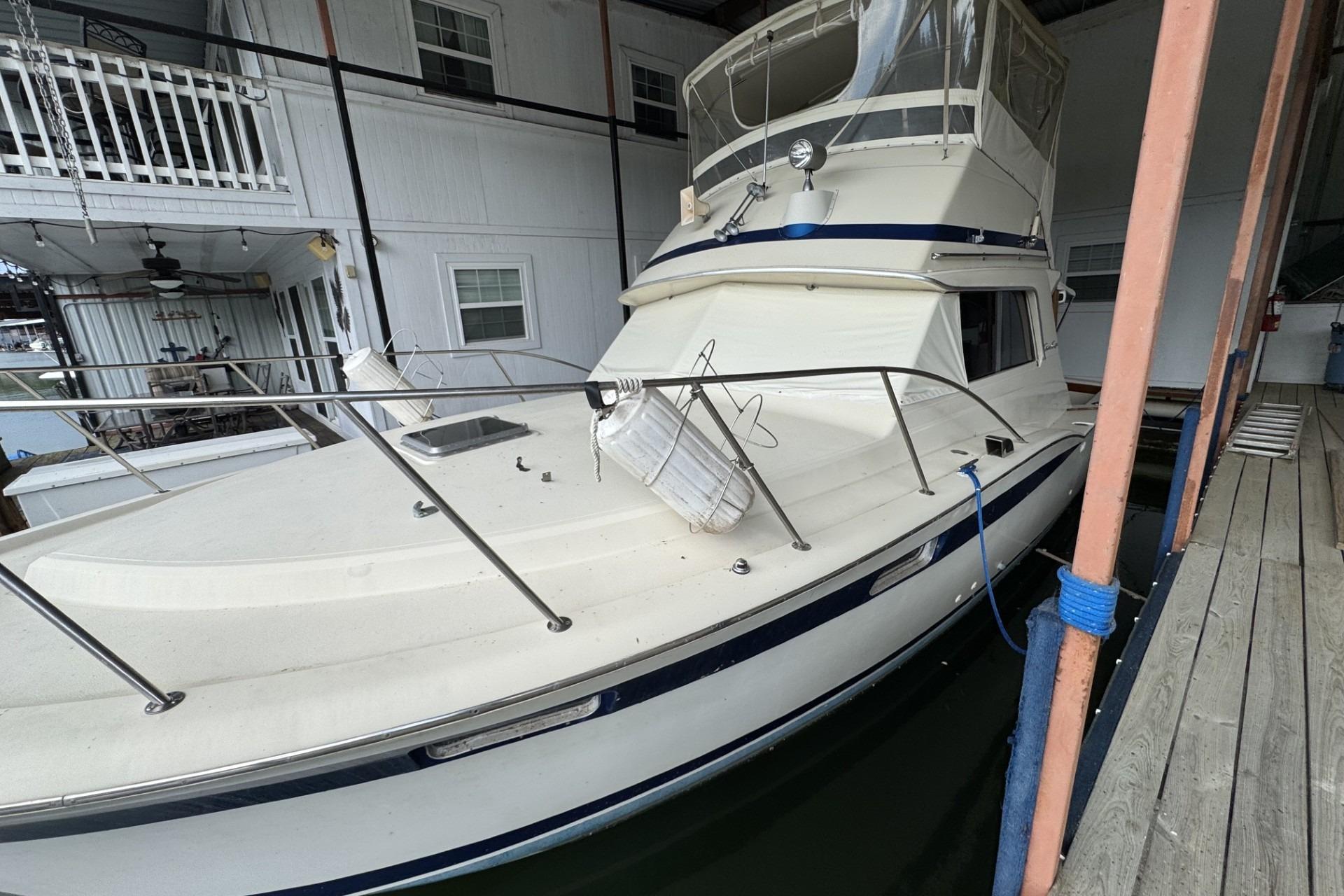 1980 Chris-Craft 360 Commander docked in a covered marina, showcasing classic design.