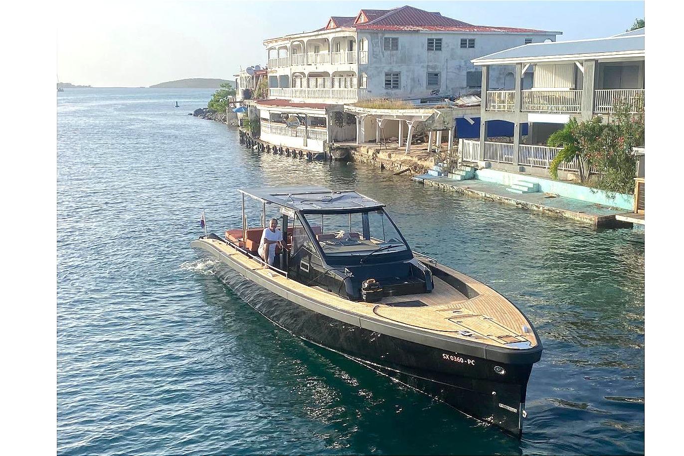 2013 Windy SR52 yacht cruising near waterfront buildings on a sunny day.