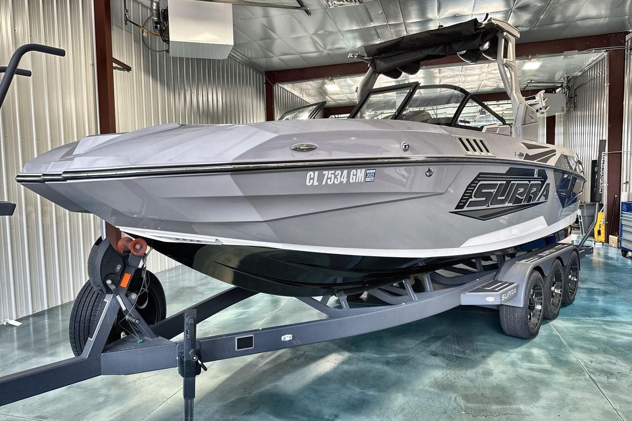 2021 Supra SE 550 boat on trailer in a metal-walled garage.