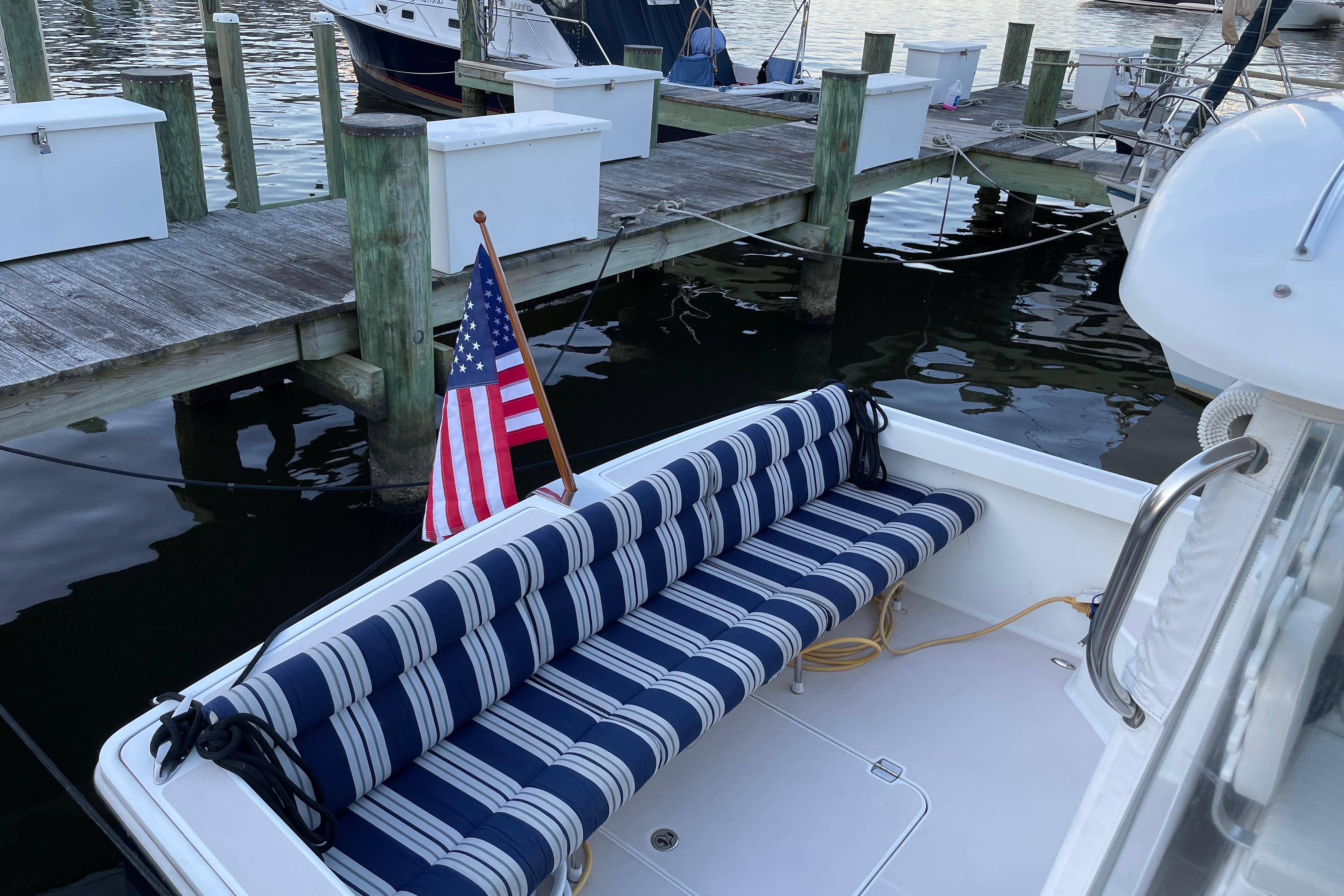 2007 Back Cove 29 boat with striped seating and American flag at dock.