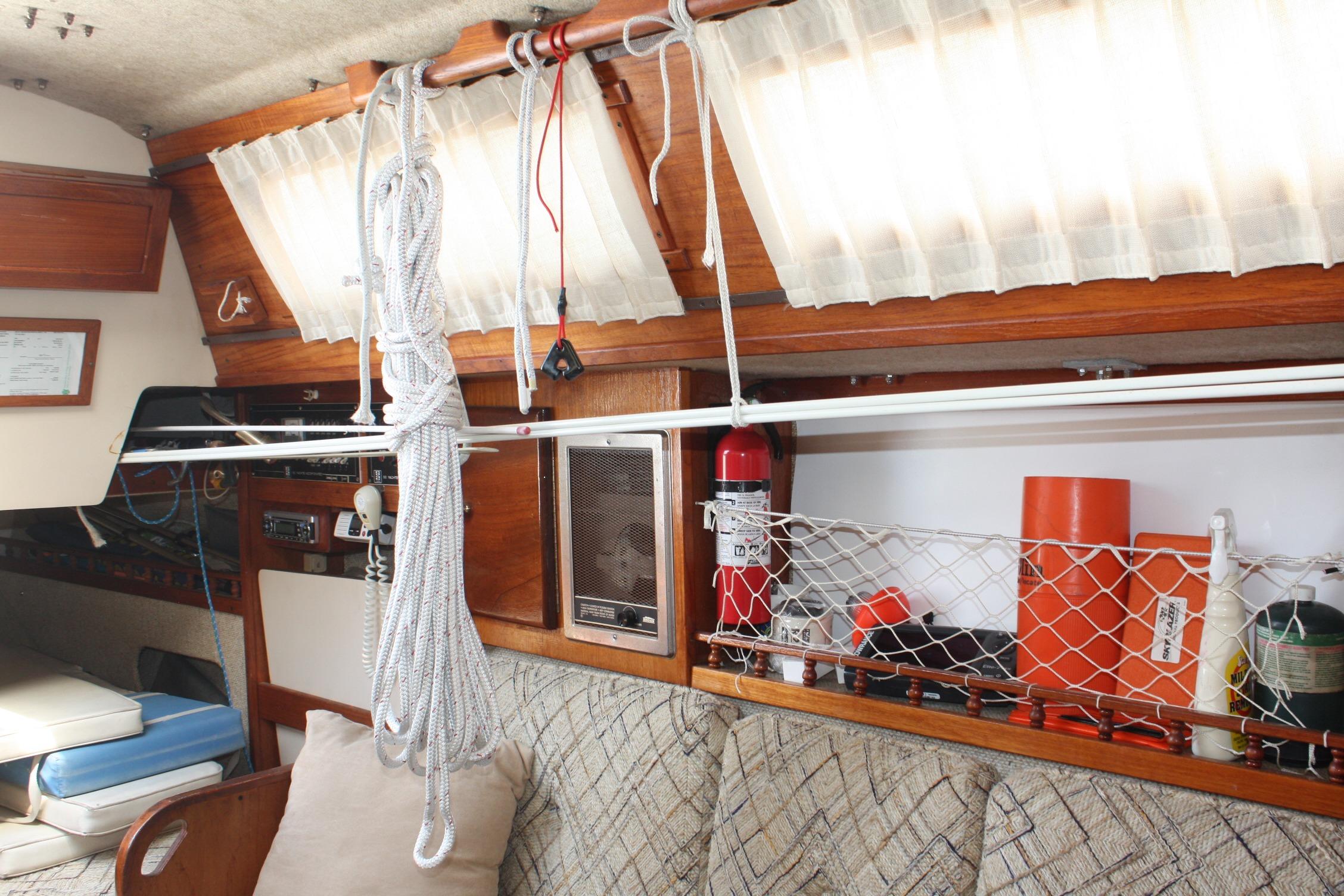 Interior of 1981 S2 9.2A sailboat with ropes, fire extinguisher, and storage netting.