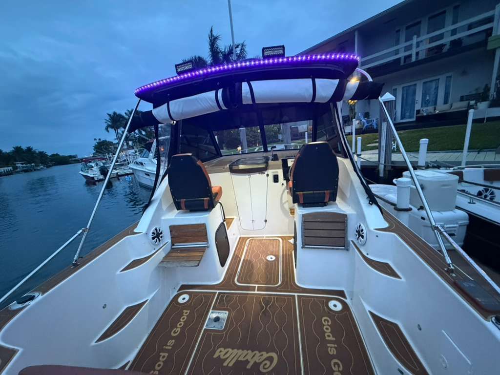 2001 Bayliner 2452 Ciera Classic with illuminated cockpit and wood flooring, docked by the water.